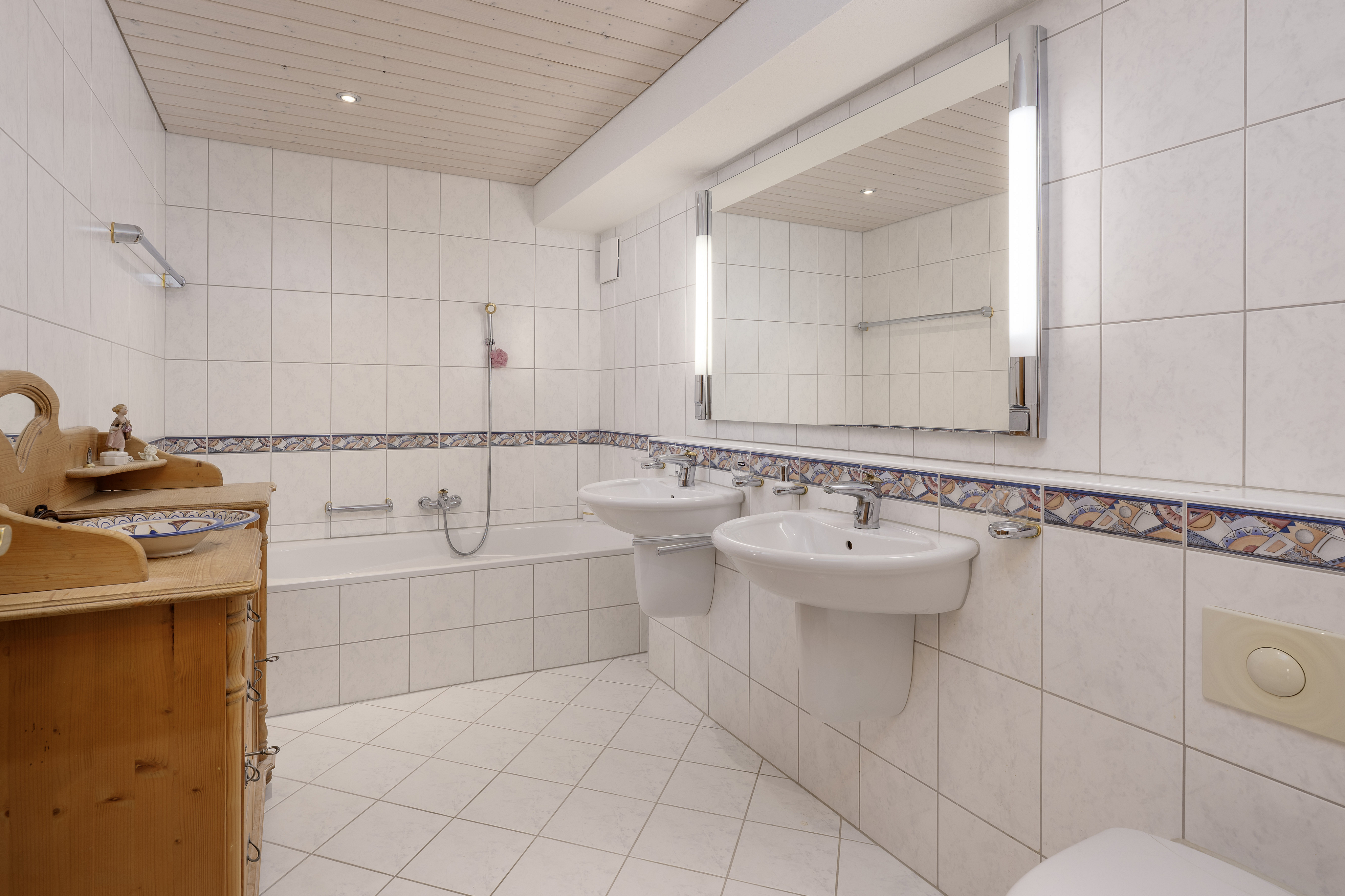 Helles Badezimmer mit Doppelwaschbecken und Wanne