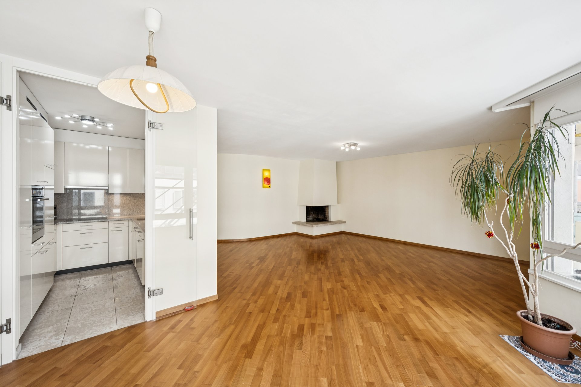 Heller Wohnraum mit offener Küchenzone und Kamin