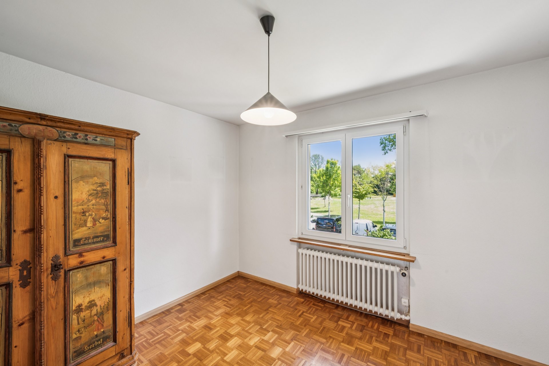 Helles Zimmer mit Parkett, Fenster und Kleiderschrank