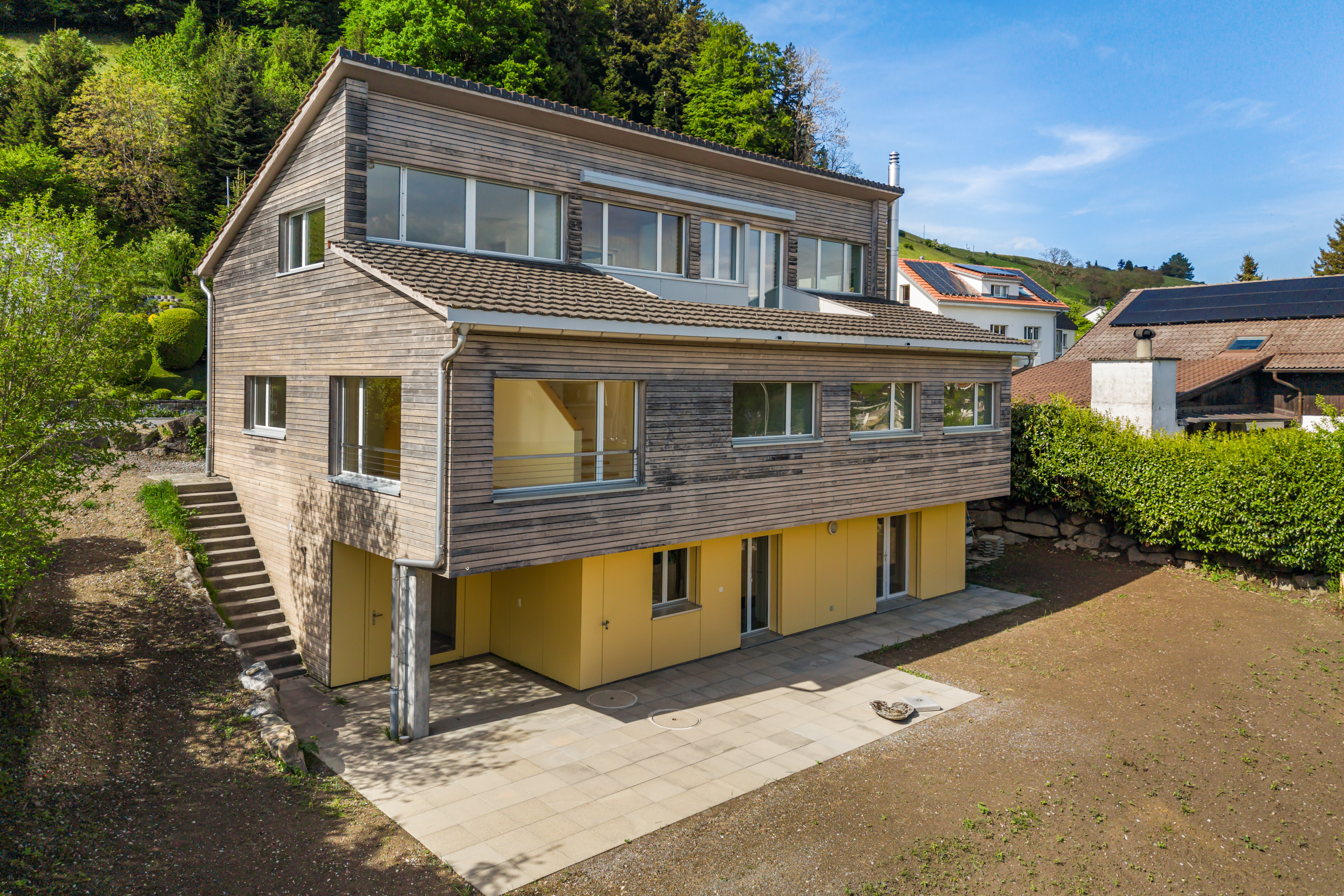 Modernes Wohnhaus mit Holzfassade und Garten