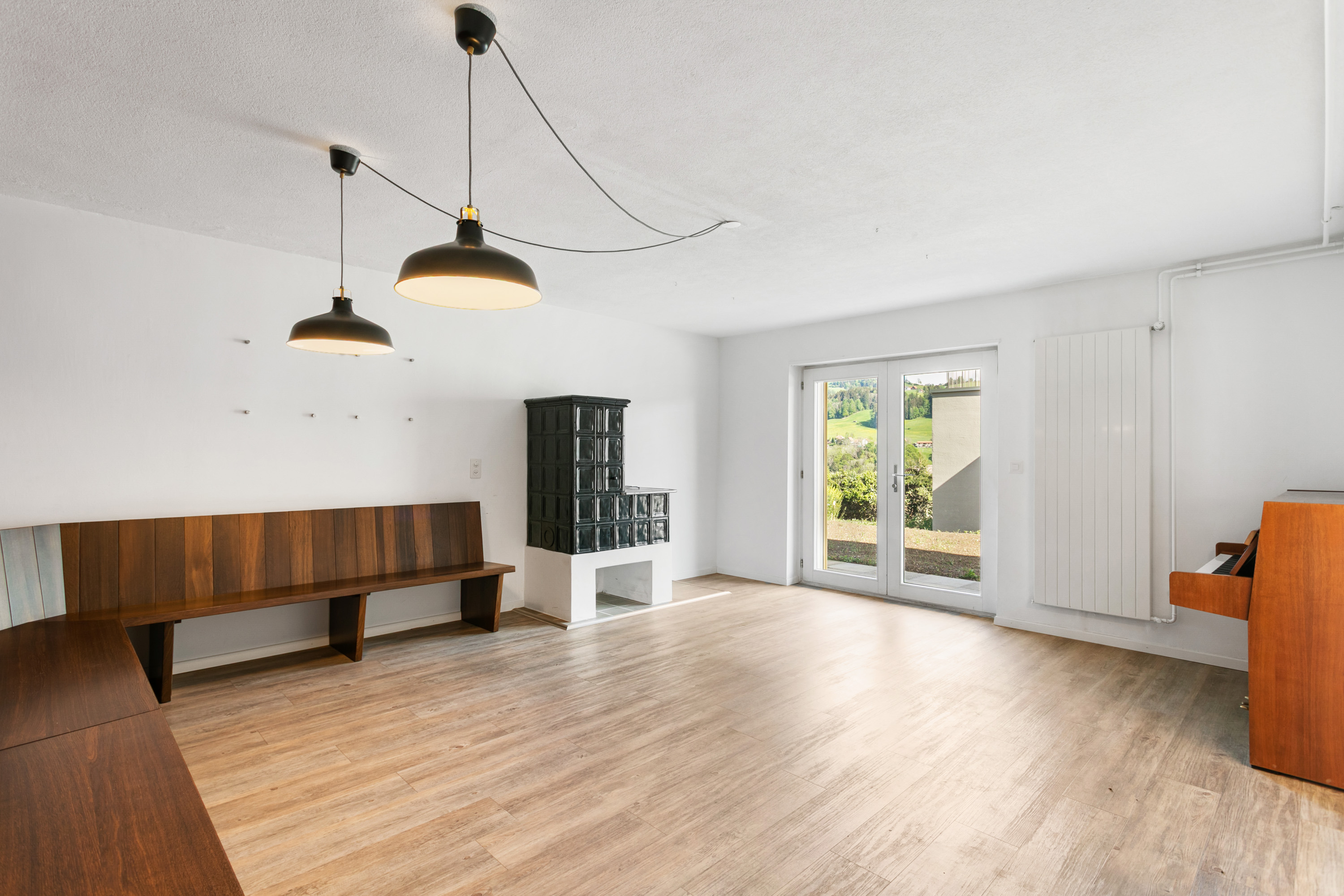 Heller Wohnraum mit Holzofen und Terrassentür