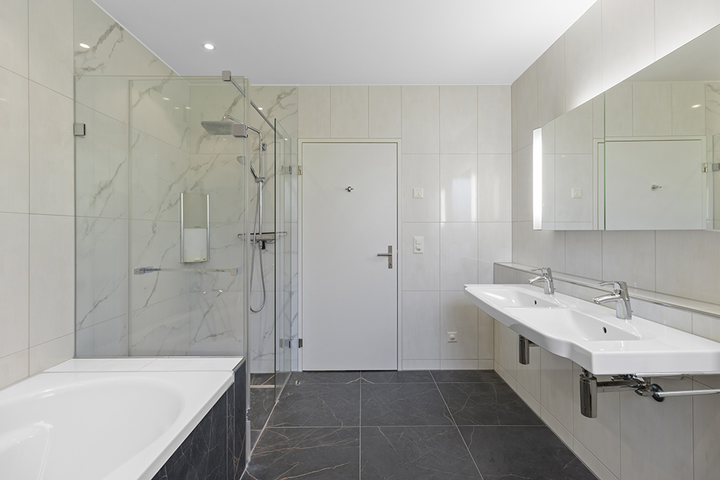Modernes Badezimmer mit Wanne, Doppelwaschbecken und Glasdusche