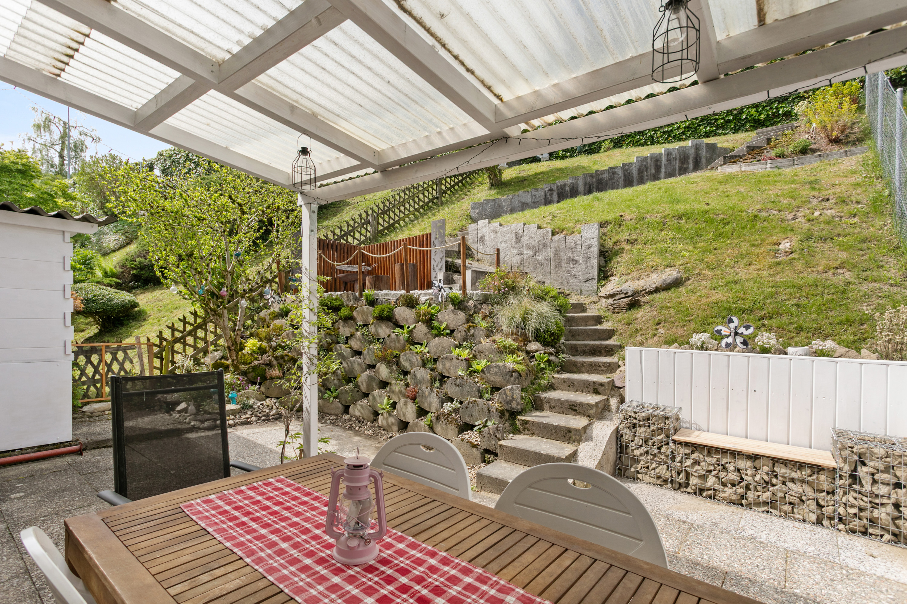 Überdachter Patio mit Gartenblick