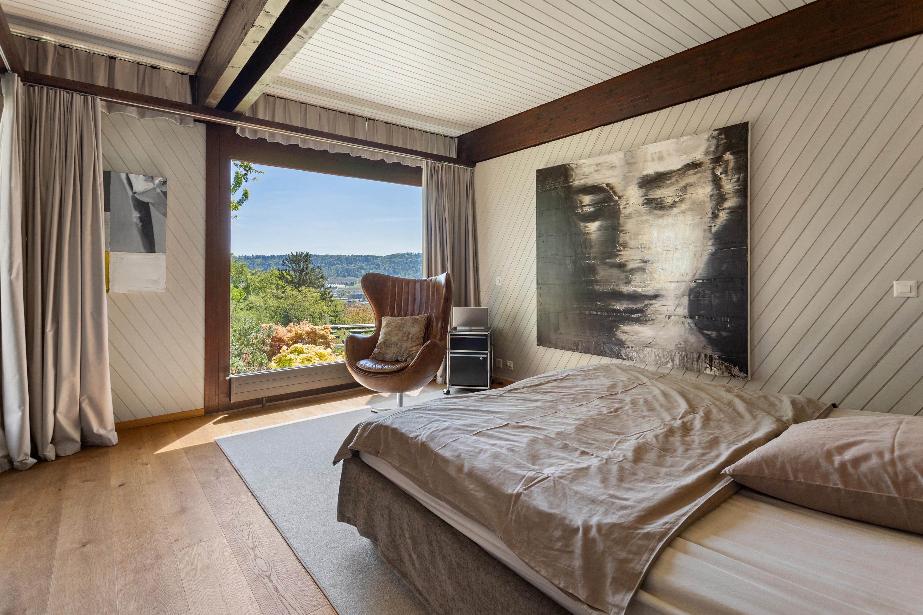 Schlafzimmer mit großem Fenster und Bergblick
