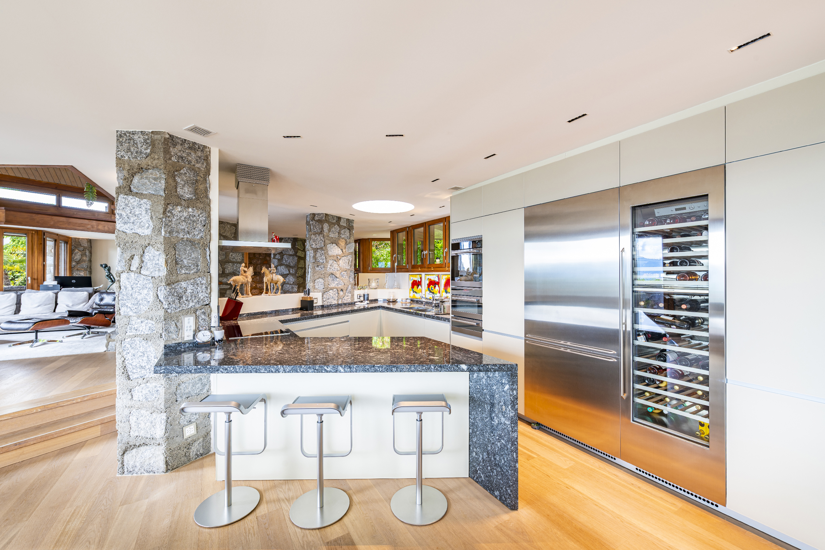 Offene moderne Küche mit Naturstein und Weinkühlschrank