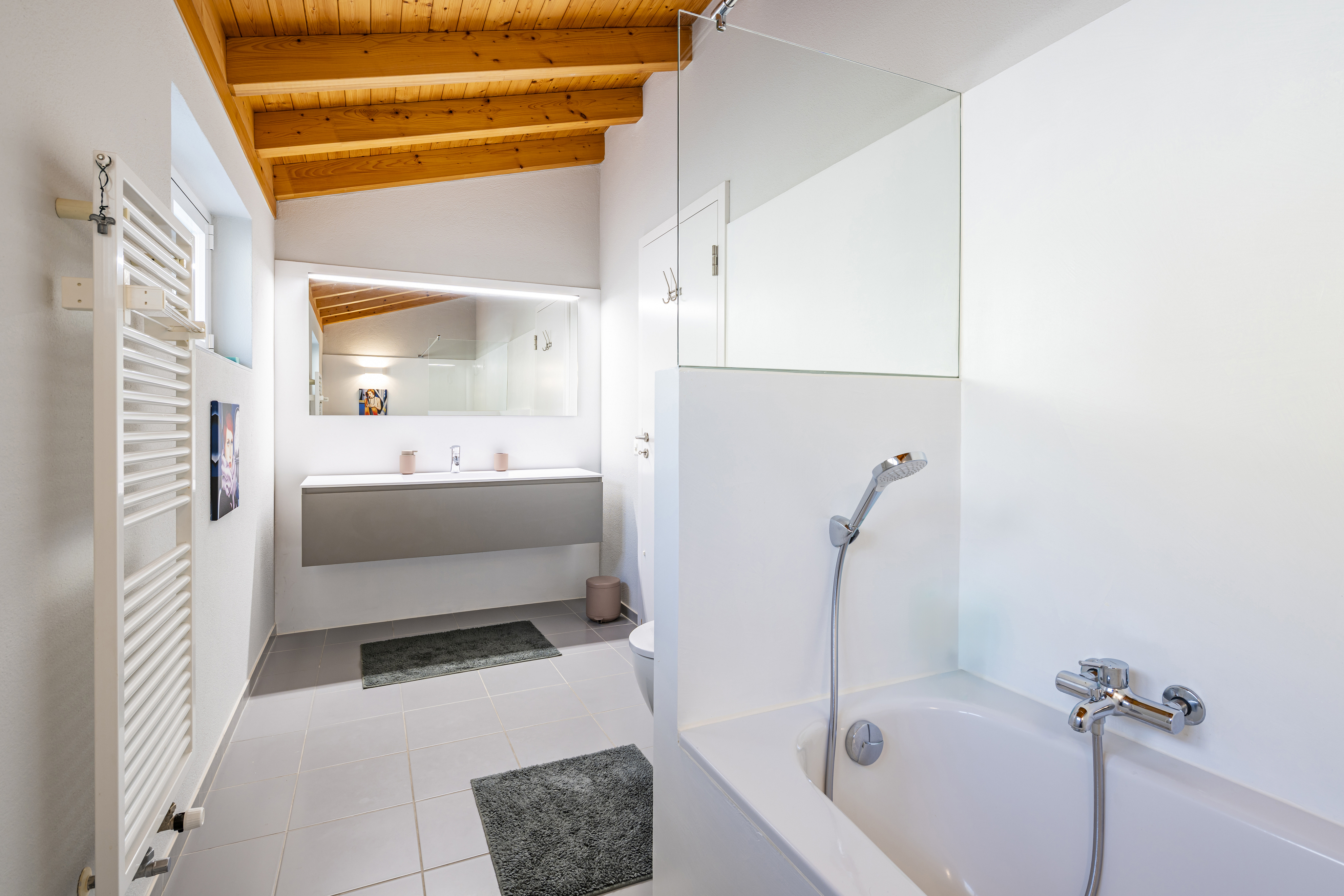 Modernes Badezimmer mit Badewanne und Dachbalken