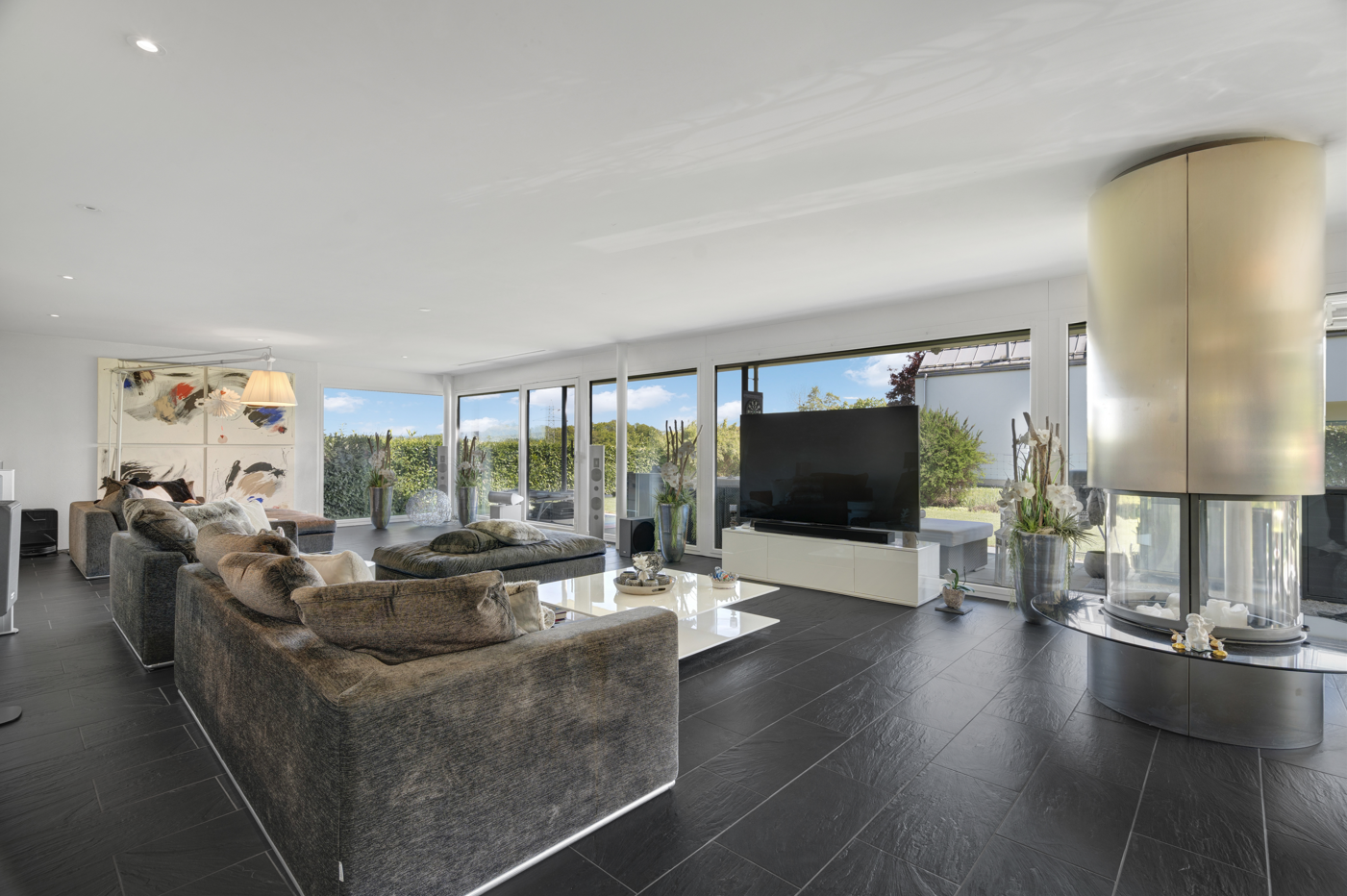 Großzügiges modernes Wohnzimmer mit Kamin und Panoramafenstern