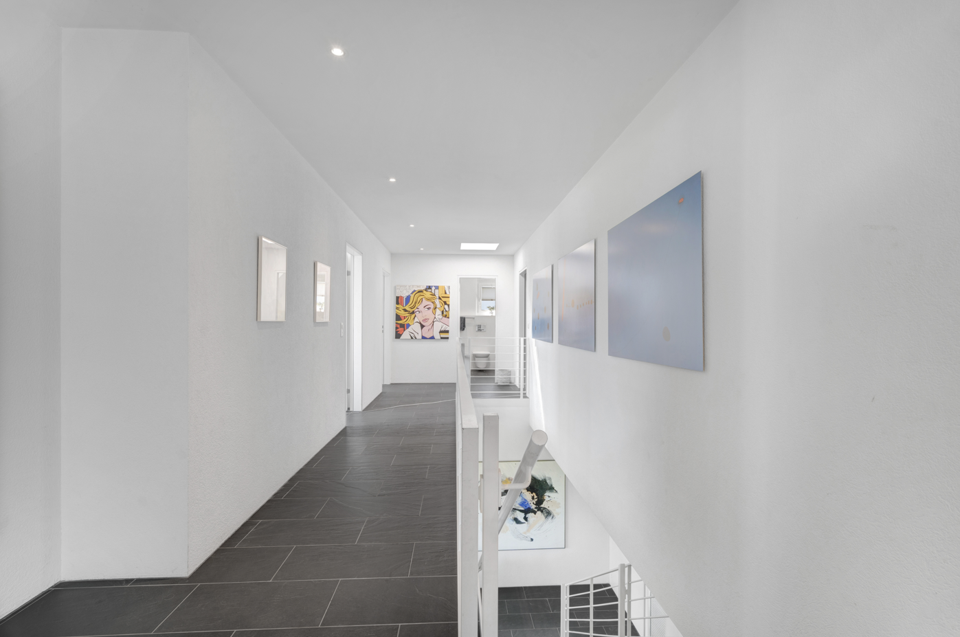 Heller Flur mit Galerie und Kunstwerken