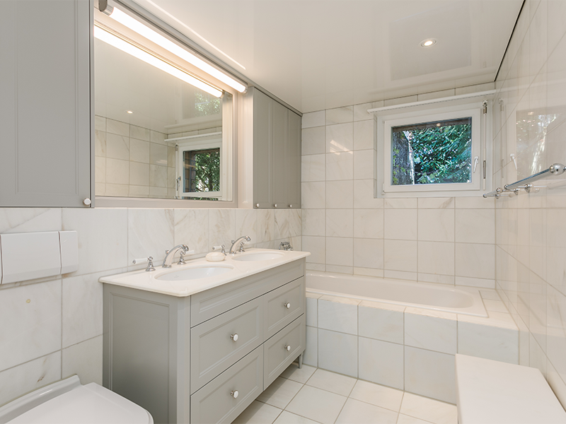 Helles Badezimmer mit Doppelwaschbecken und Badewanne