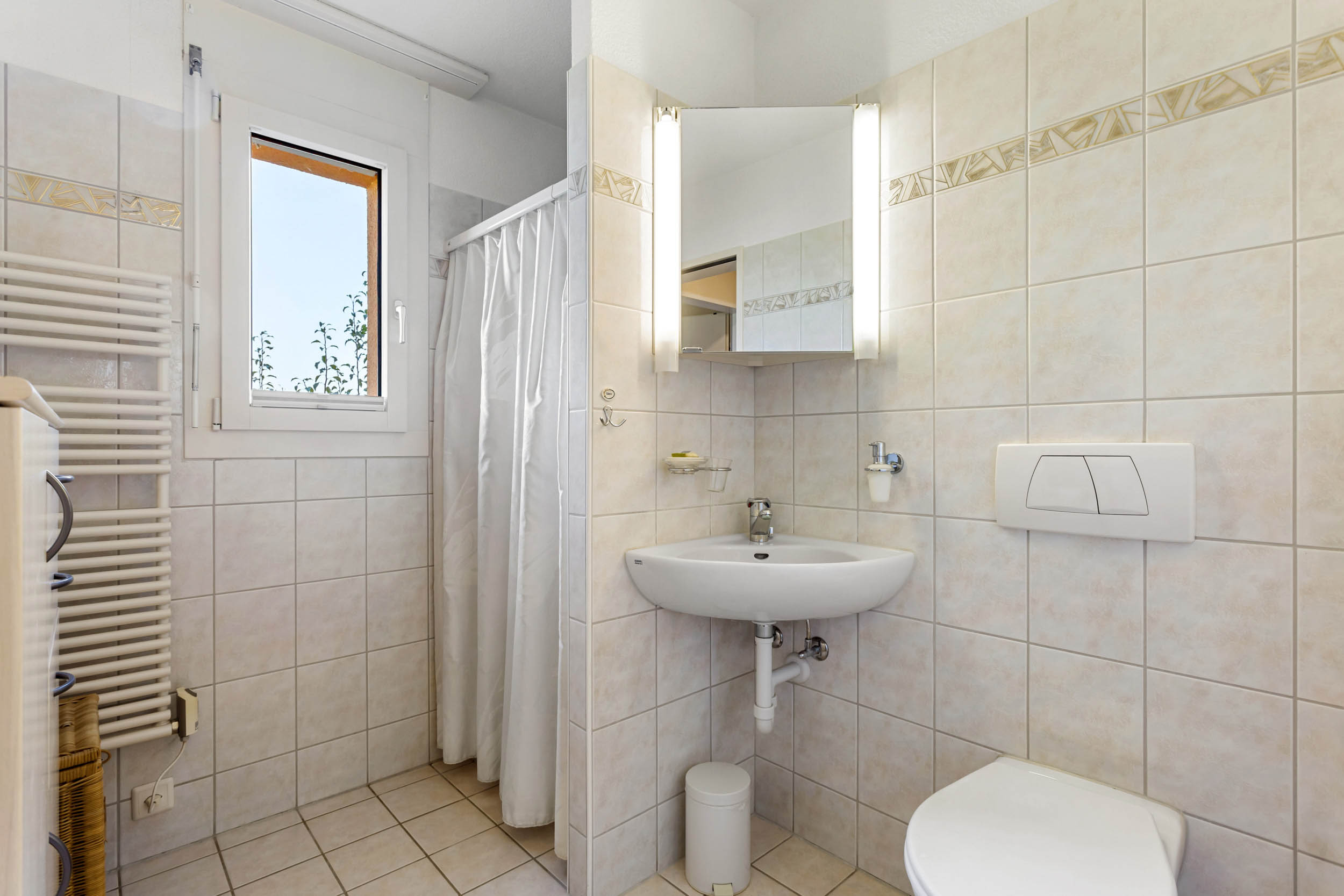 Kleines, helles Badezimmer mit WC und Waschtisch