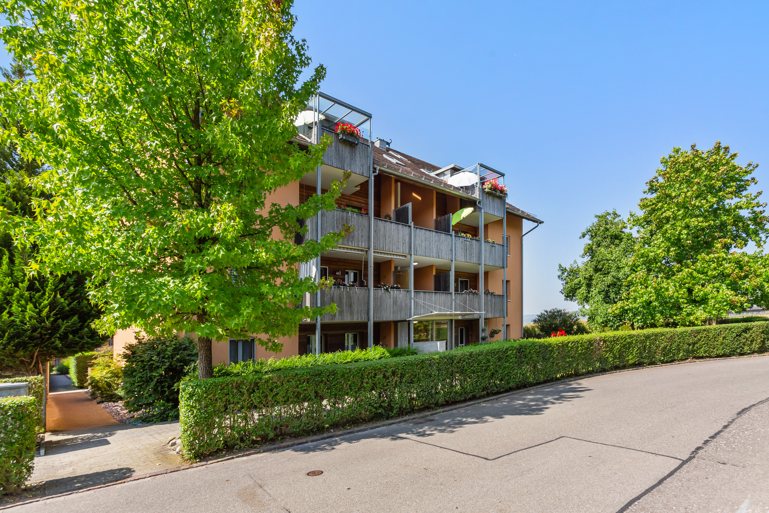 Mehrfamilienhaus mit Balkonen und viel Grün