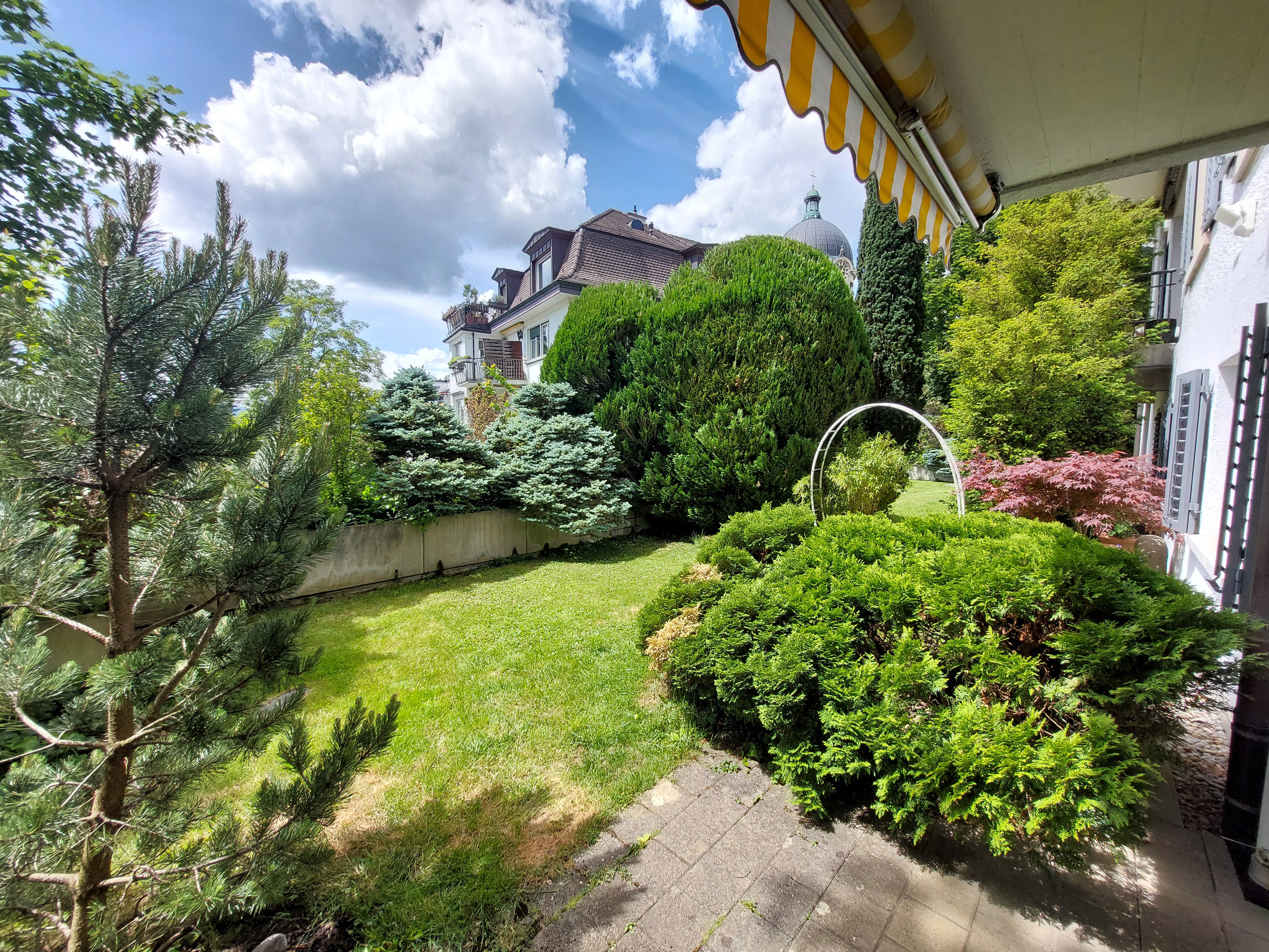 Gepflegter Garten mit Blick auf Wohngebäude
