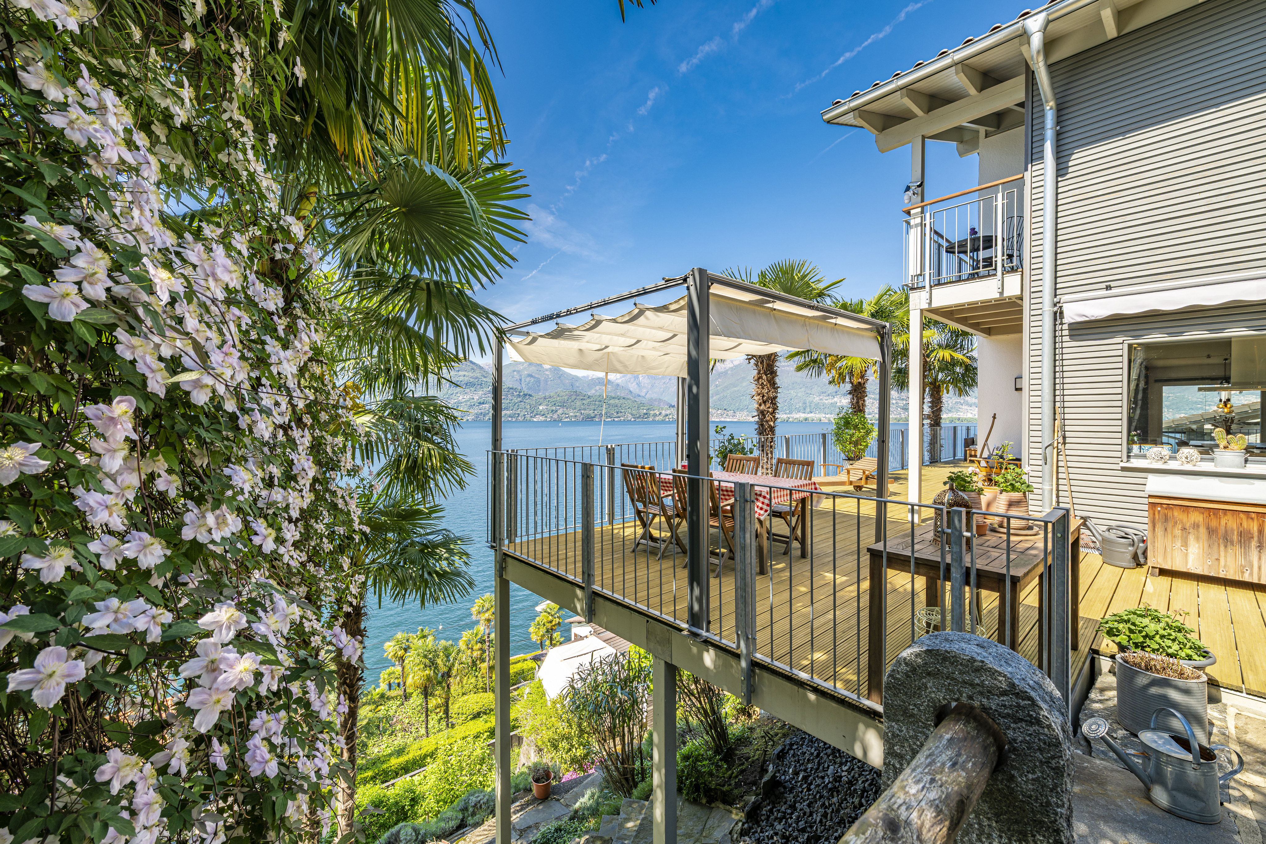 Terrasse mit Seeblick und tropischer Bepflanzung