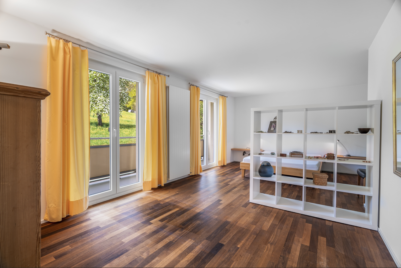 Helles Schlafzimmer mit Balkon und Parkettboden
