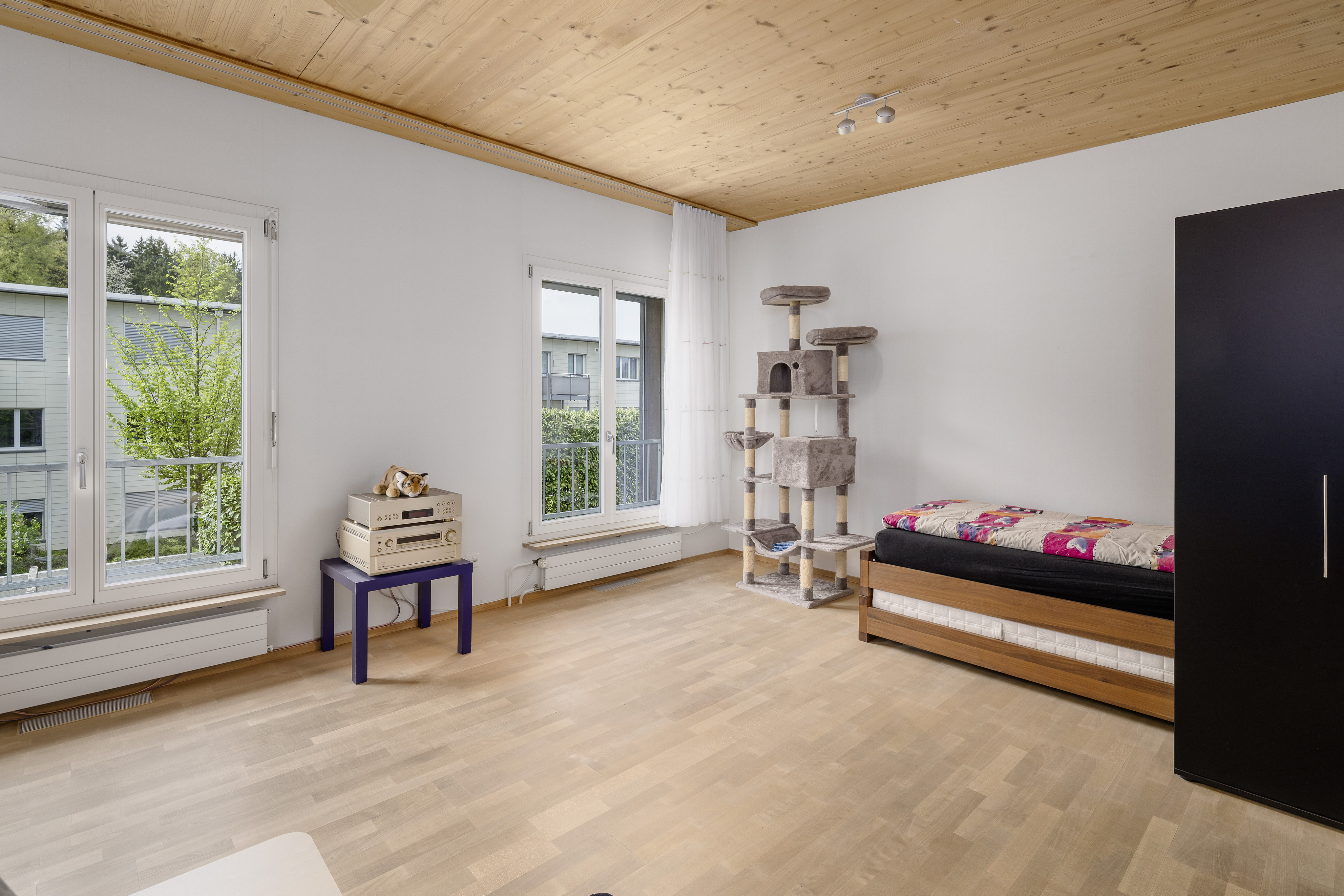 Helles Schlafzimmer mit Holzdecke und Balkonblick
