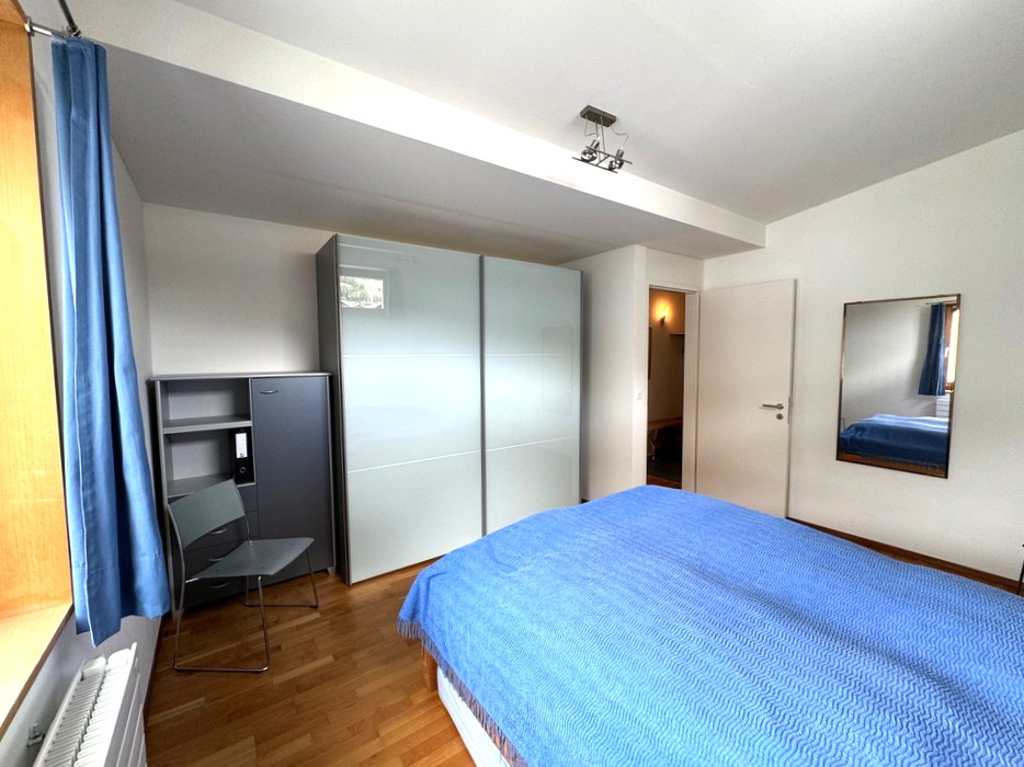 Helles Schlafzimmer mit blauem Bett