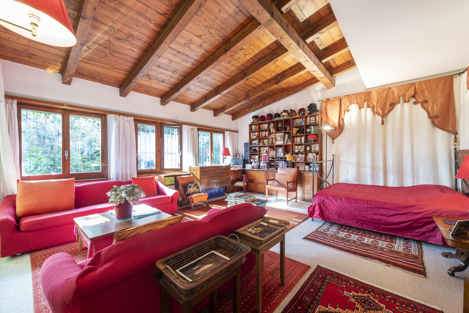 Gemütliches Wohnzimmer mit Holzdecke und bunten Textilien