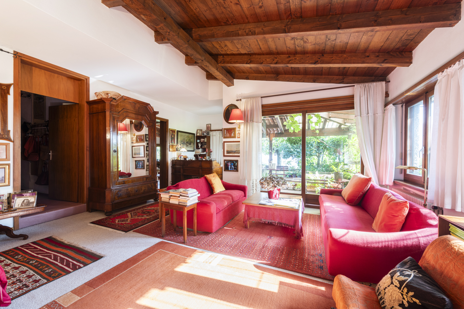 Wohnzimmer mit Holzbalkendecke und großen Fenstern