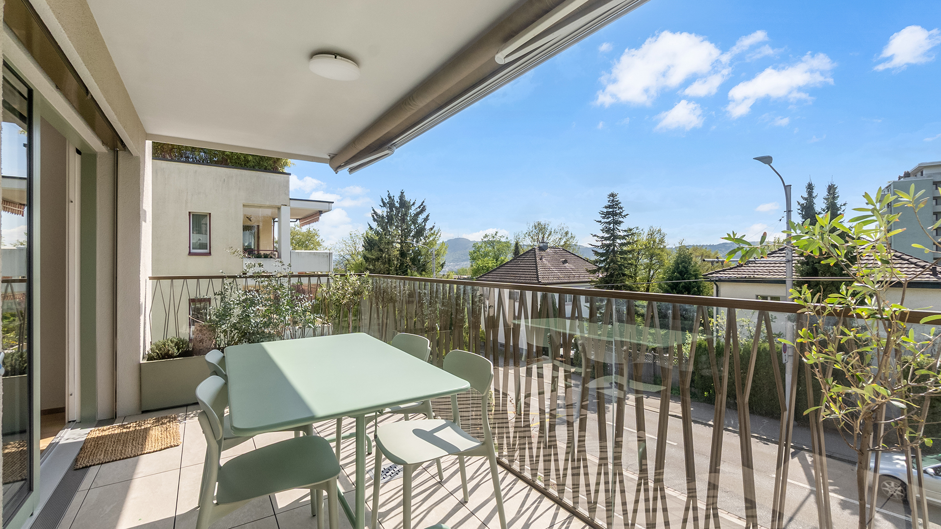 Heller Balkon mit Tisch und Blick ins Grüne