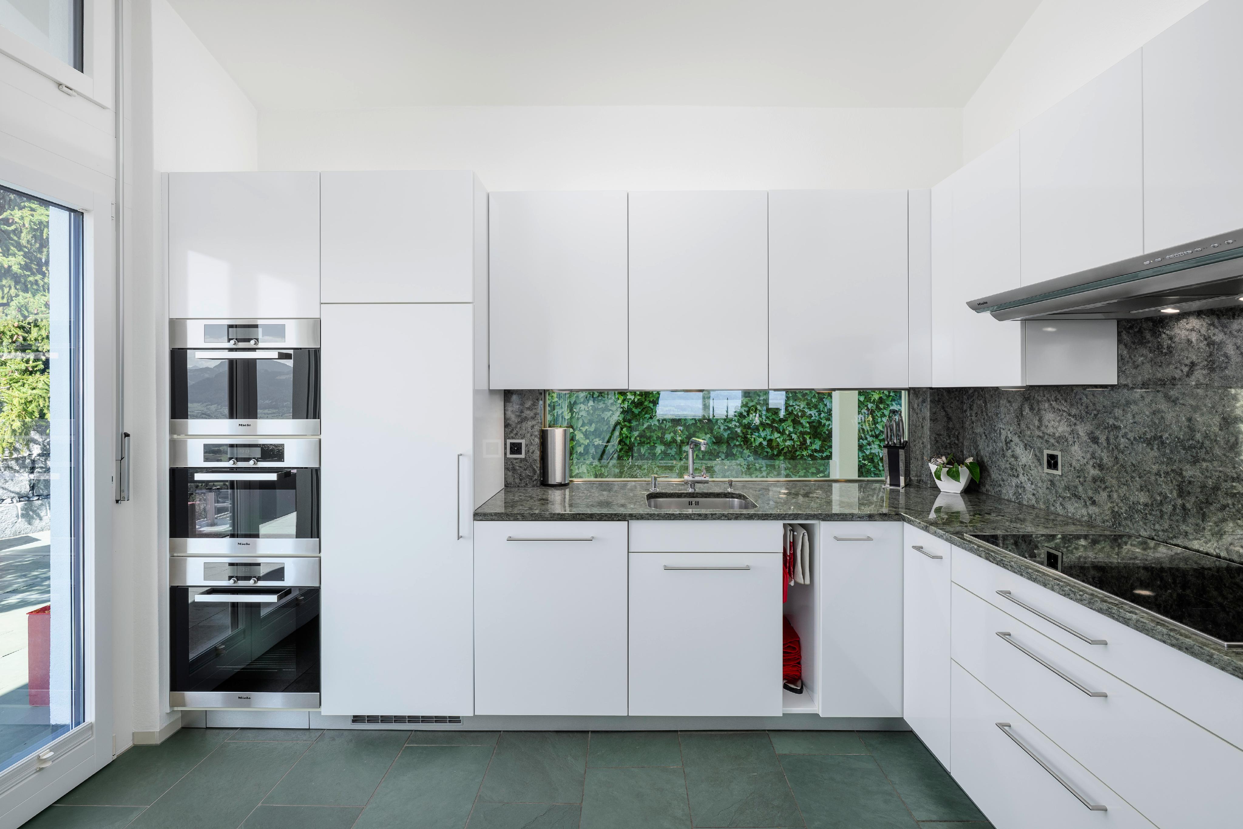 Moderne weiße Design-Küche mit Natursteinoptik