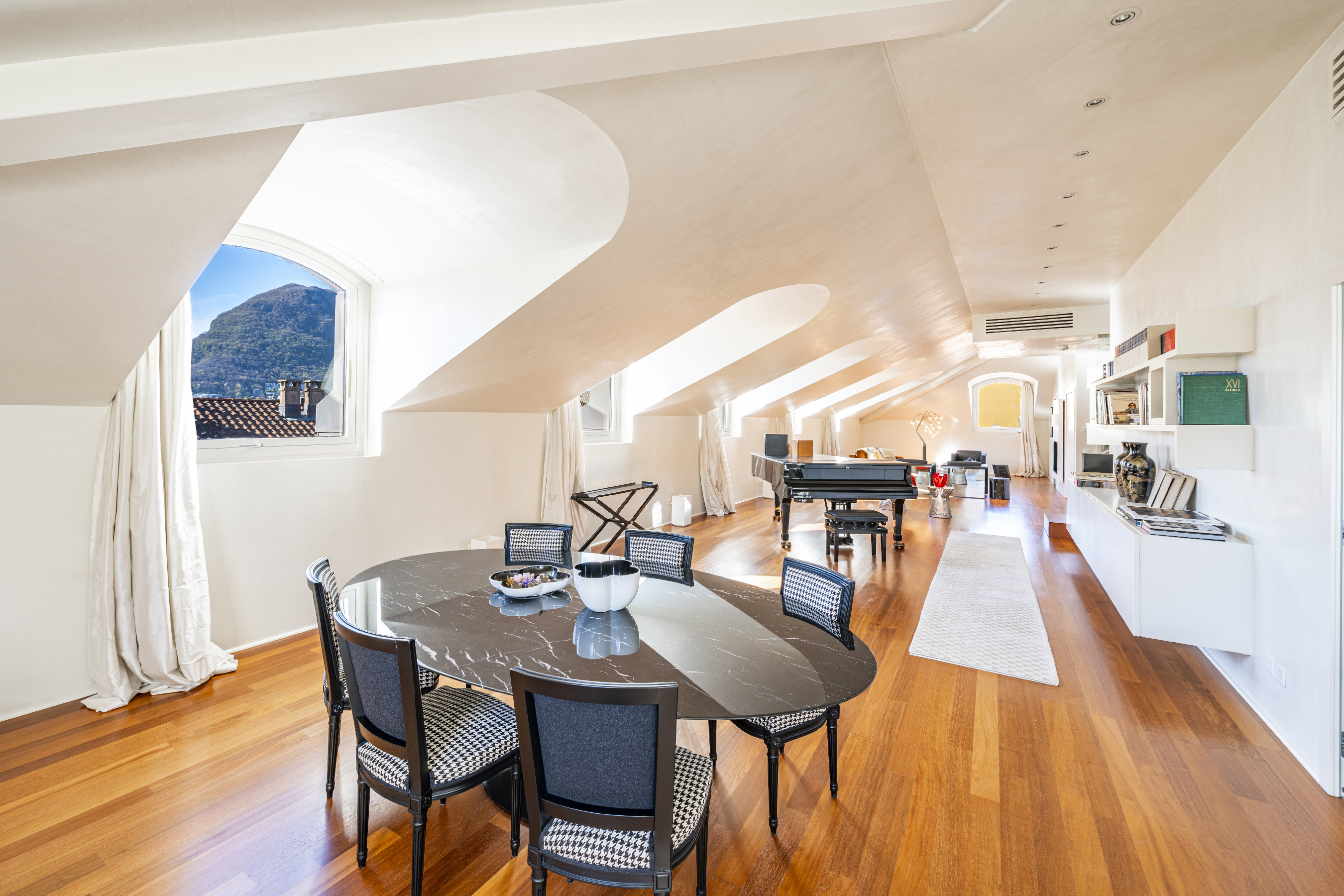 Heller Dachgeschoss-Wohnraum mit Blick auf die Berge