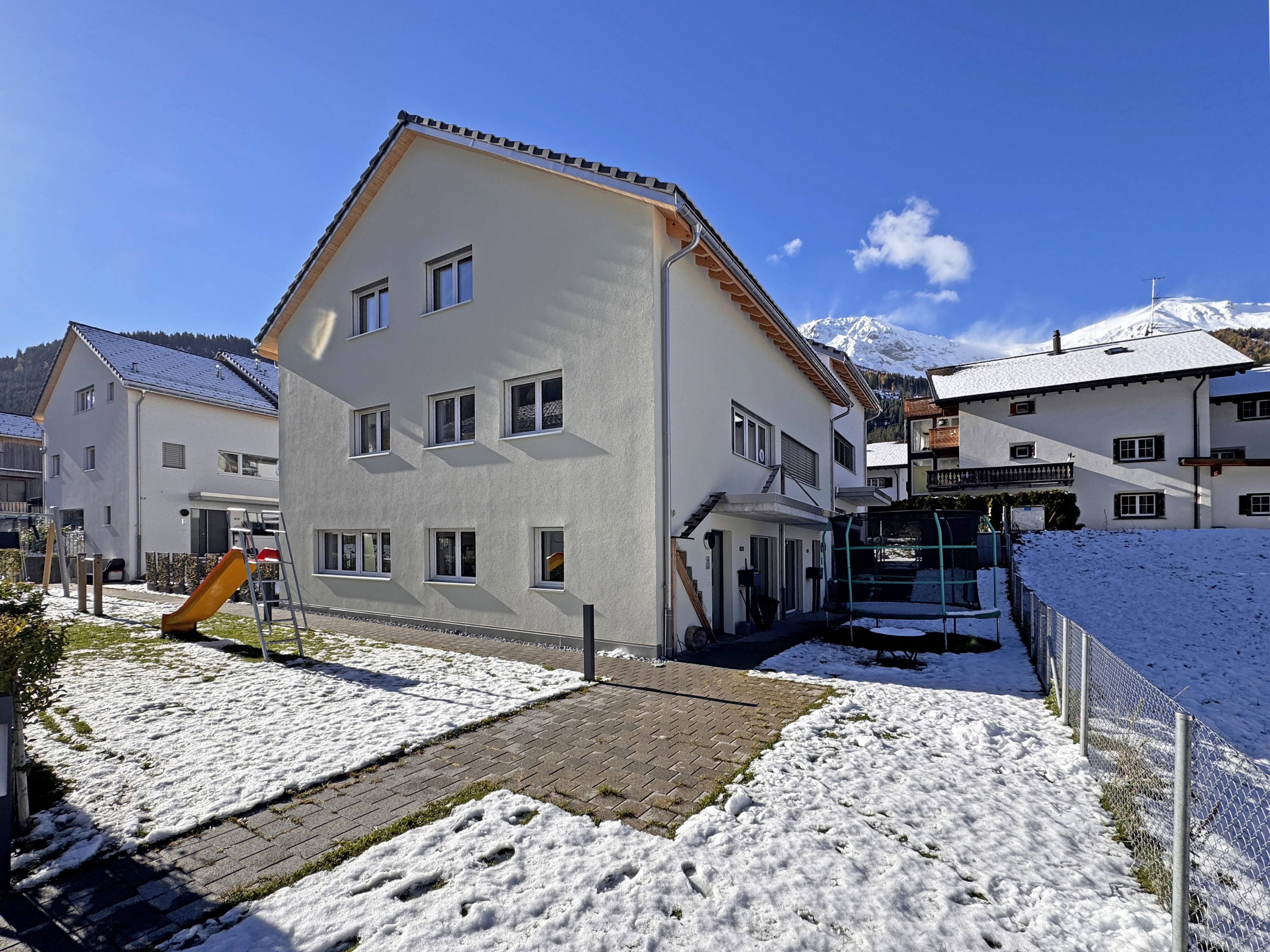 Freistehendes Haus mit verschneitem Garten und Spielbereich