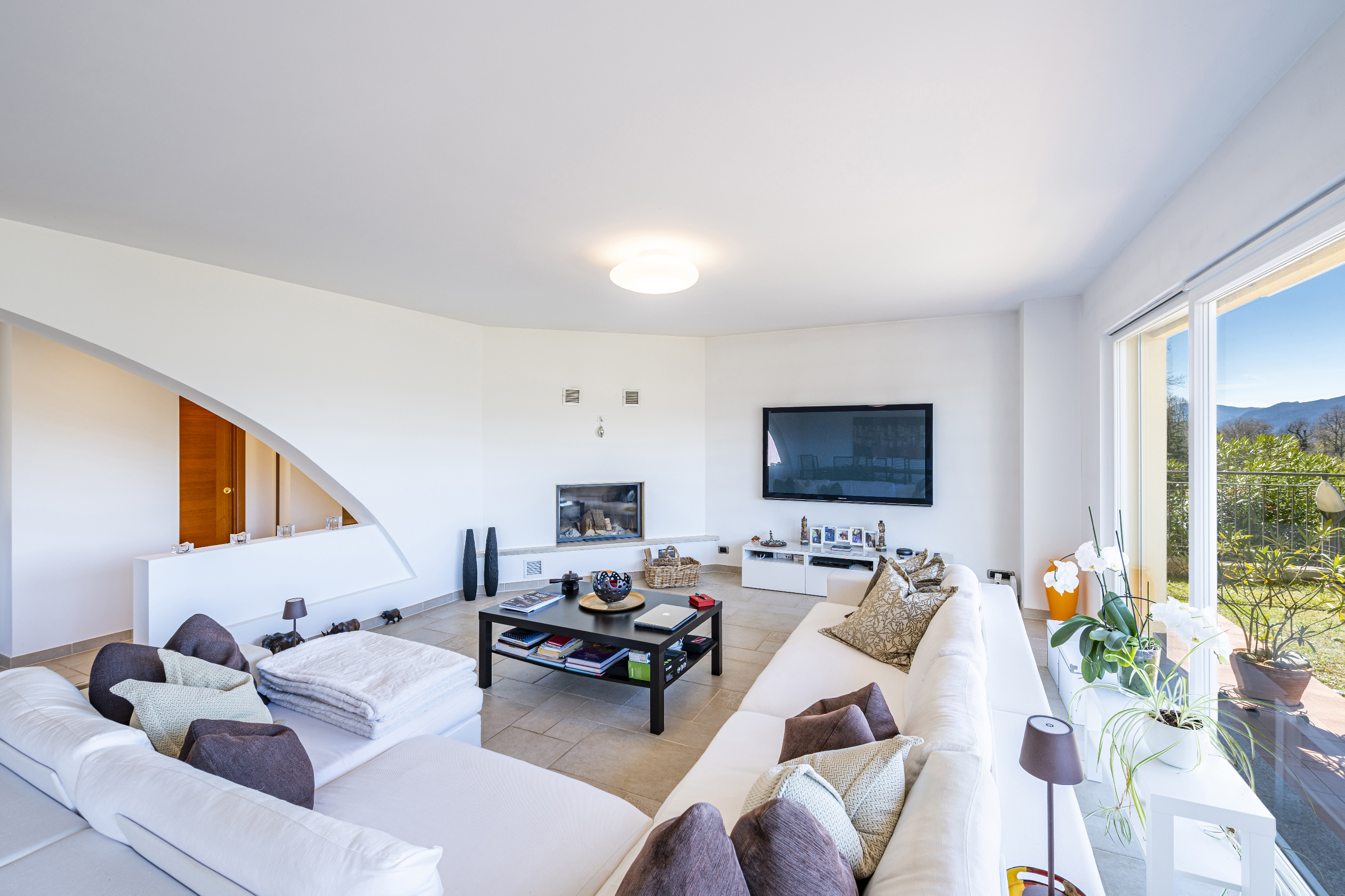 Helles Wohnzimmer mit Kamin und Balkonblick