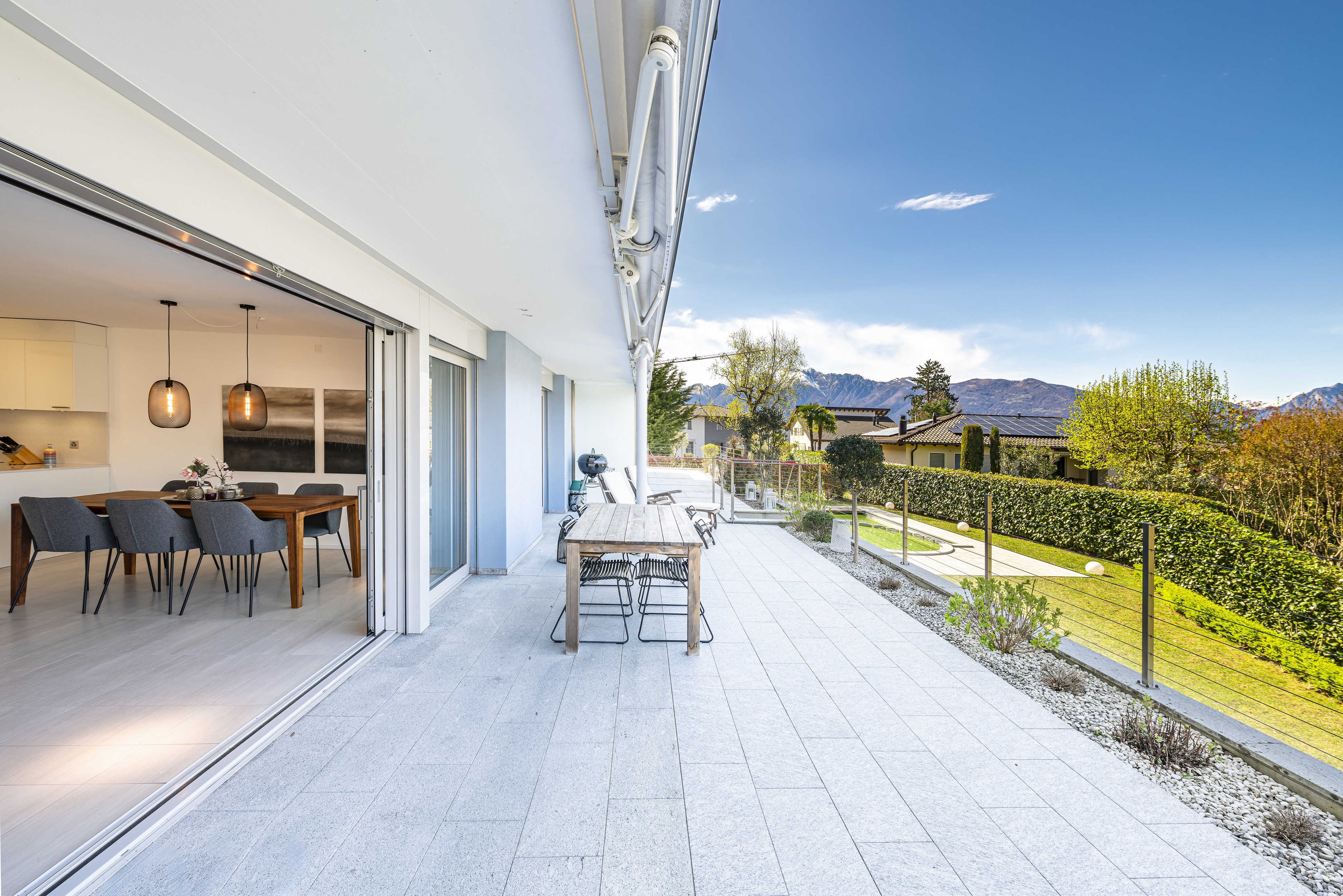 Moderne Terrasse mit Blick ins Grüne und auf Berge