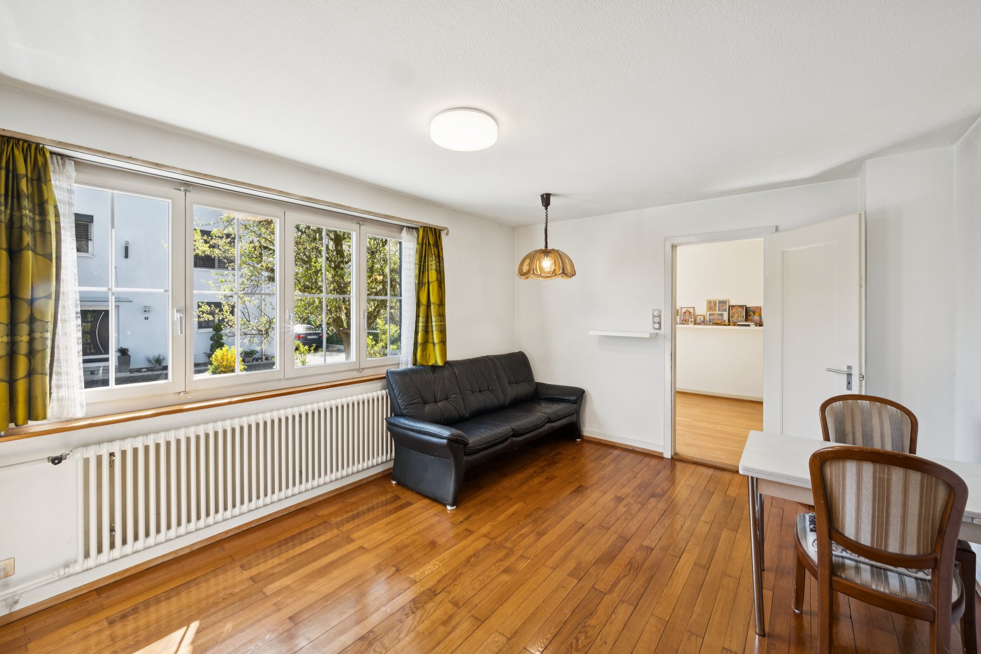 Heller Wohnraum mit Holzfußboden und Fensterfront