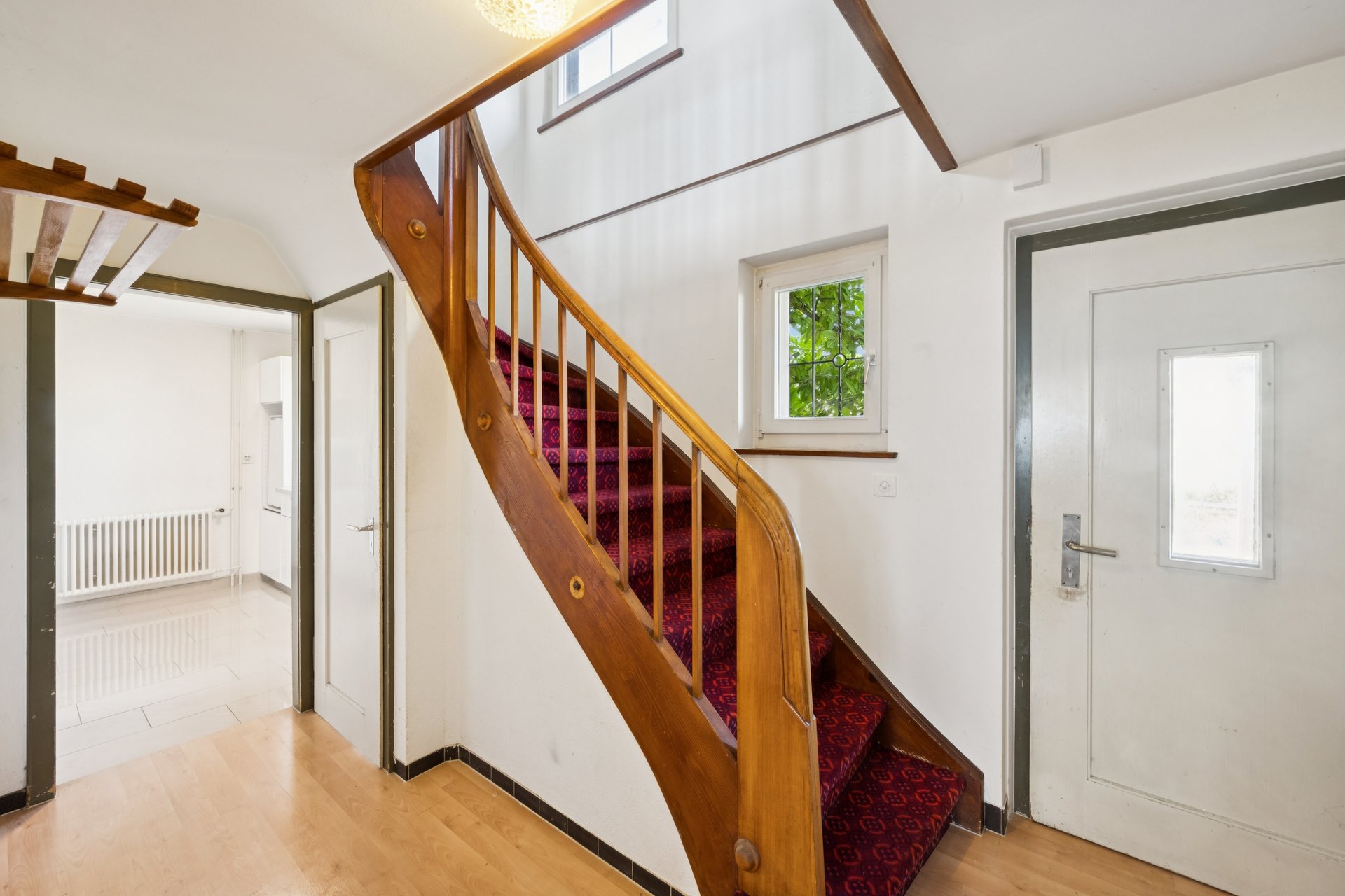 Heller Eingangsbereich mit Holztreppe