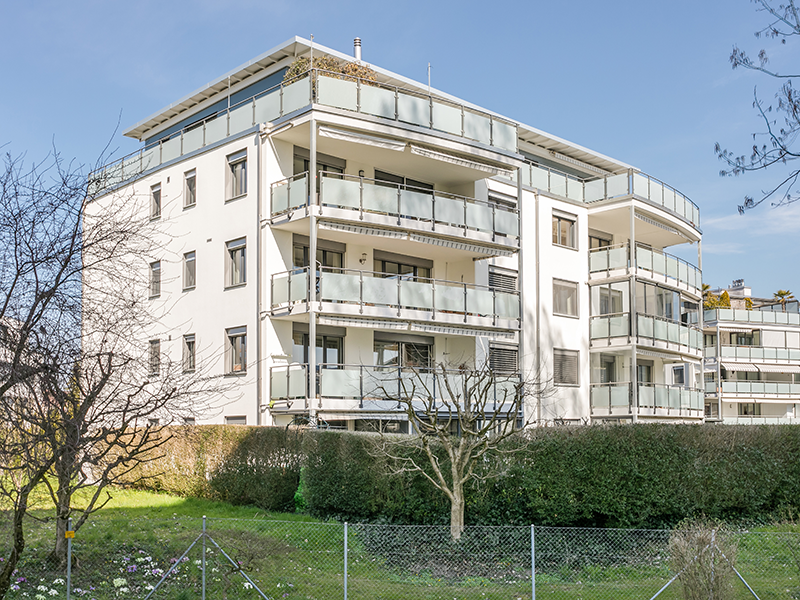 Mehrfamilienhaus mit Balkonen und Gartenansicht