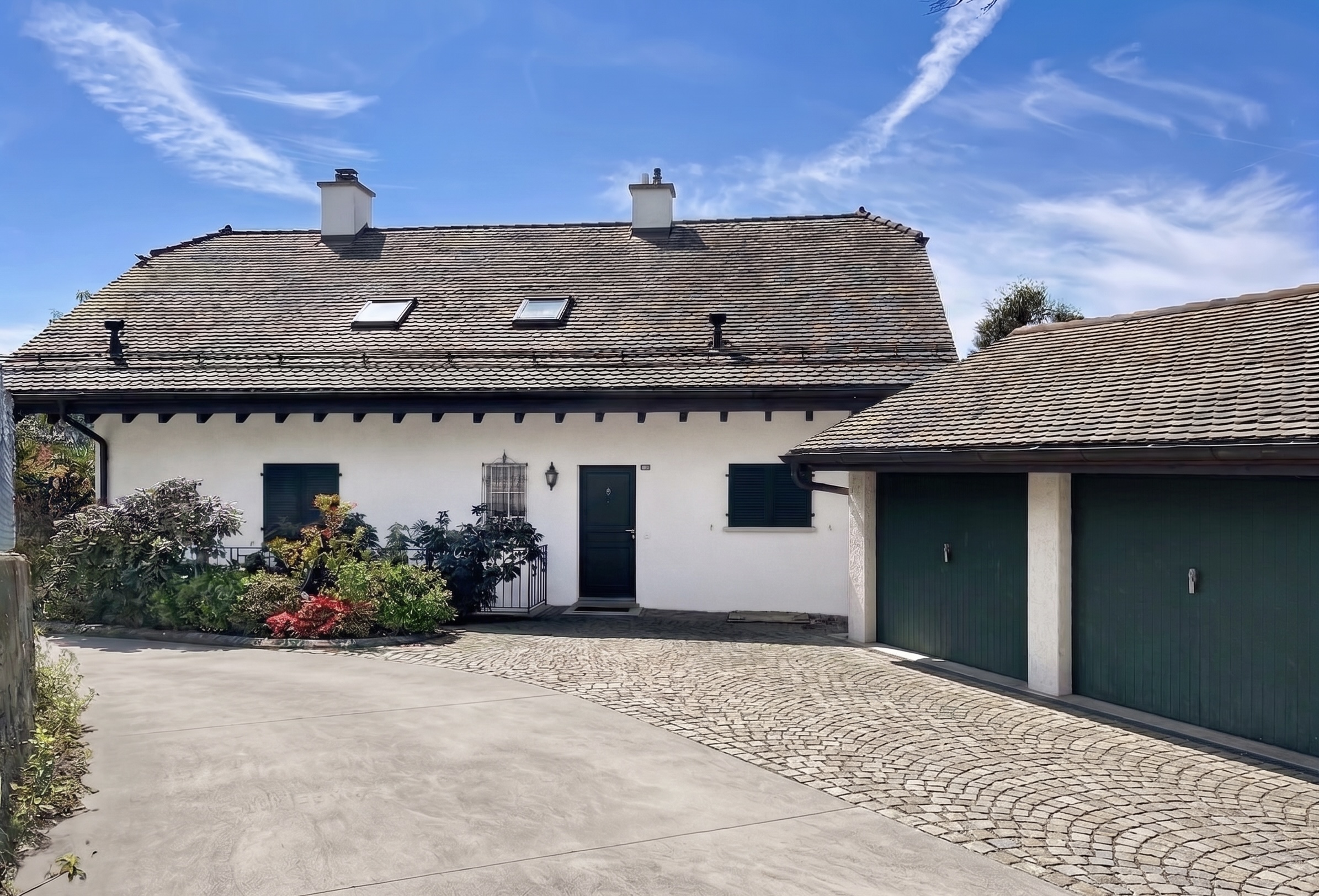Haus mit Doppelgarage und gepflasterter Zufahrt