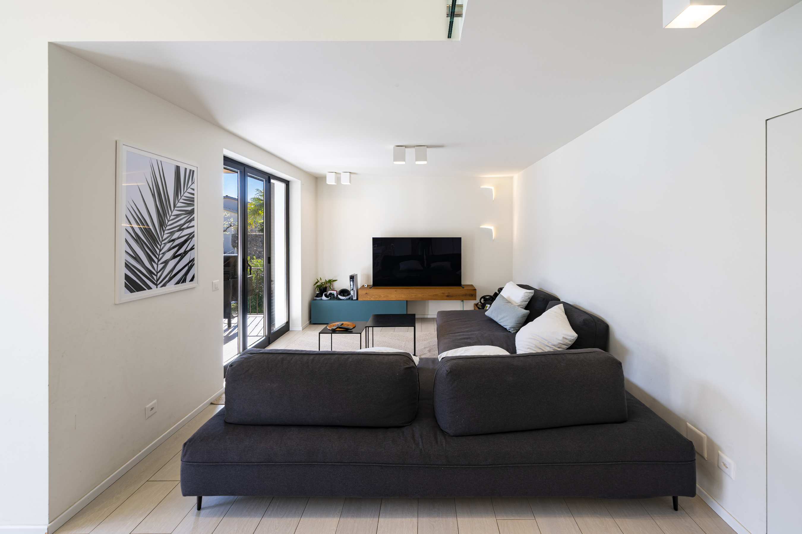 Modernes Wohnzimmer mit bodentiefen Türen und TV-Wand