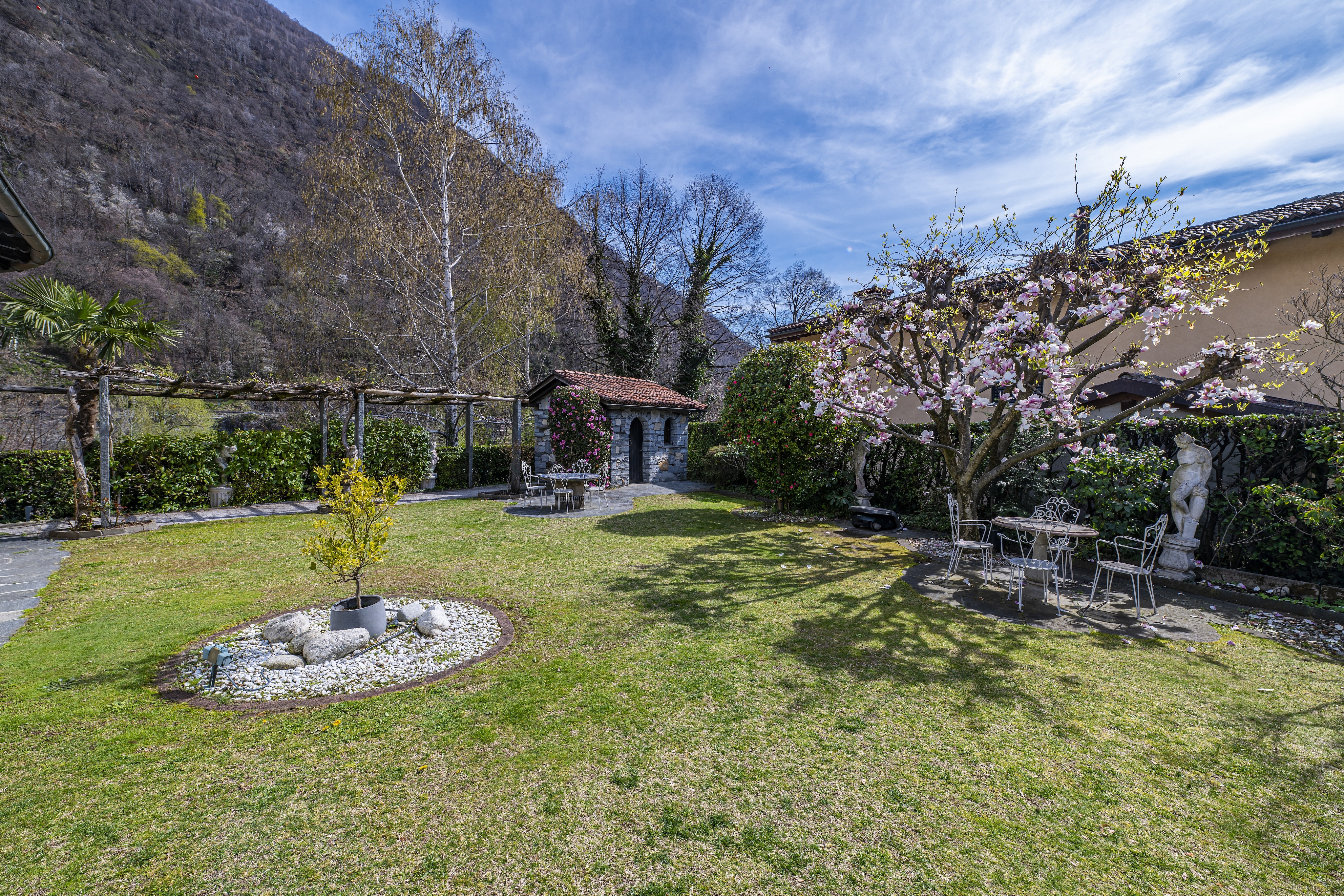 Mediterraner Garten mit Sitzplatz und Blick auf die Berge