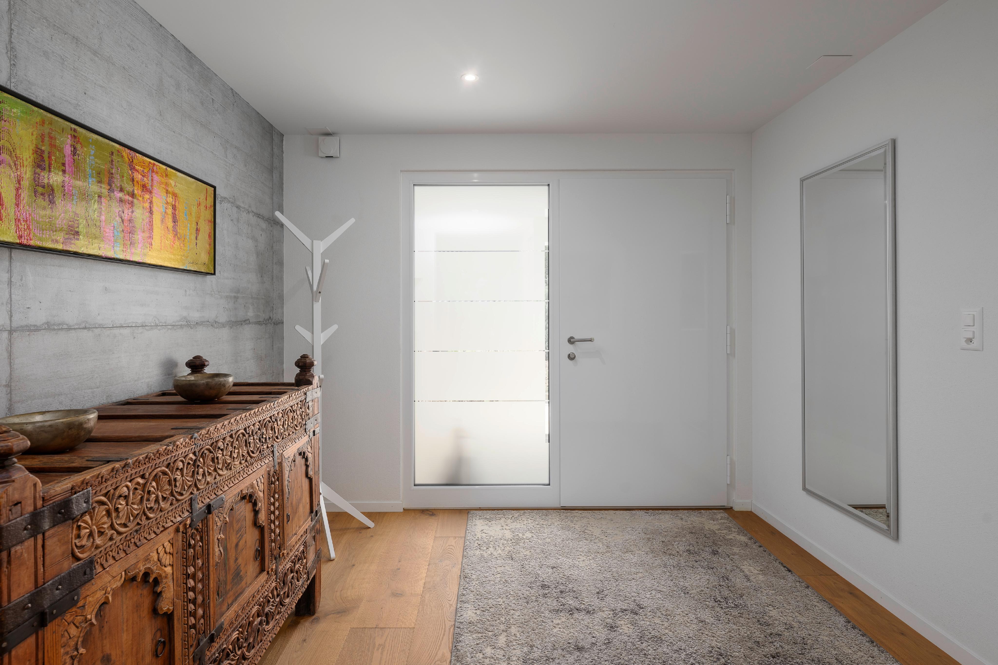 Moderner Eingangsbereich mit Kunst und Holzkommode