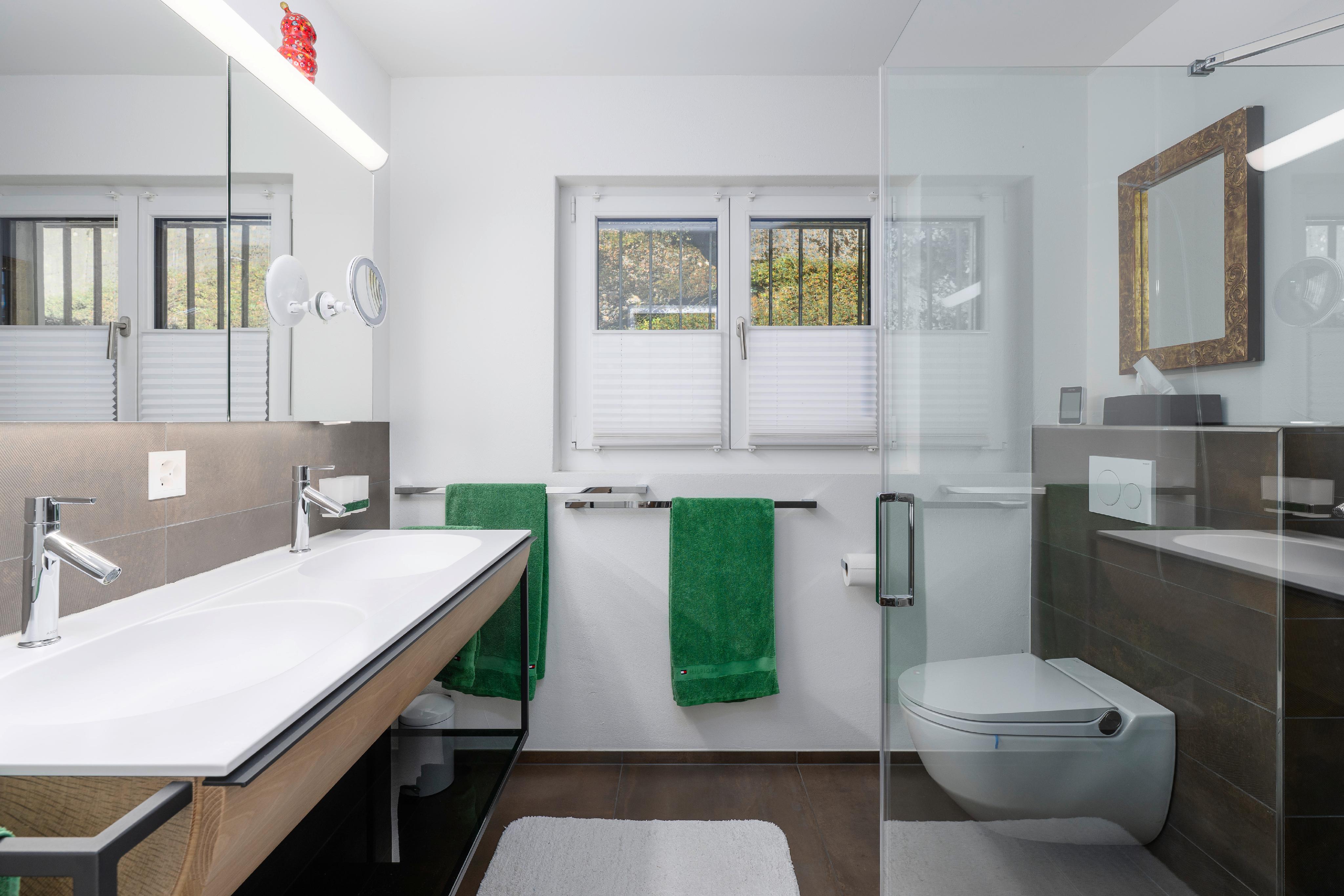 Modernes Badezimmer mit Doppelwaschbecken und Glasdusche