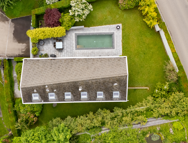 Luftaufnahme eines Hauses mit Garten und Pool