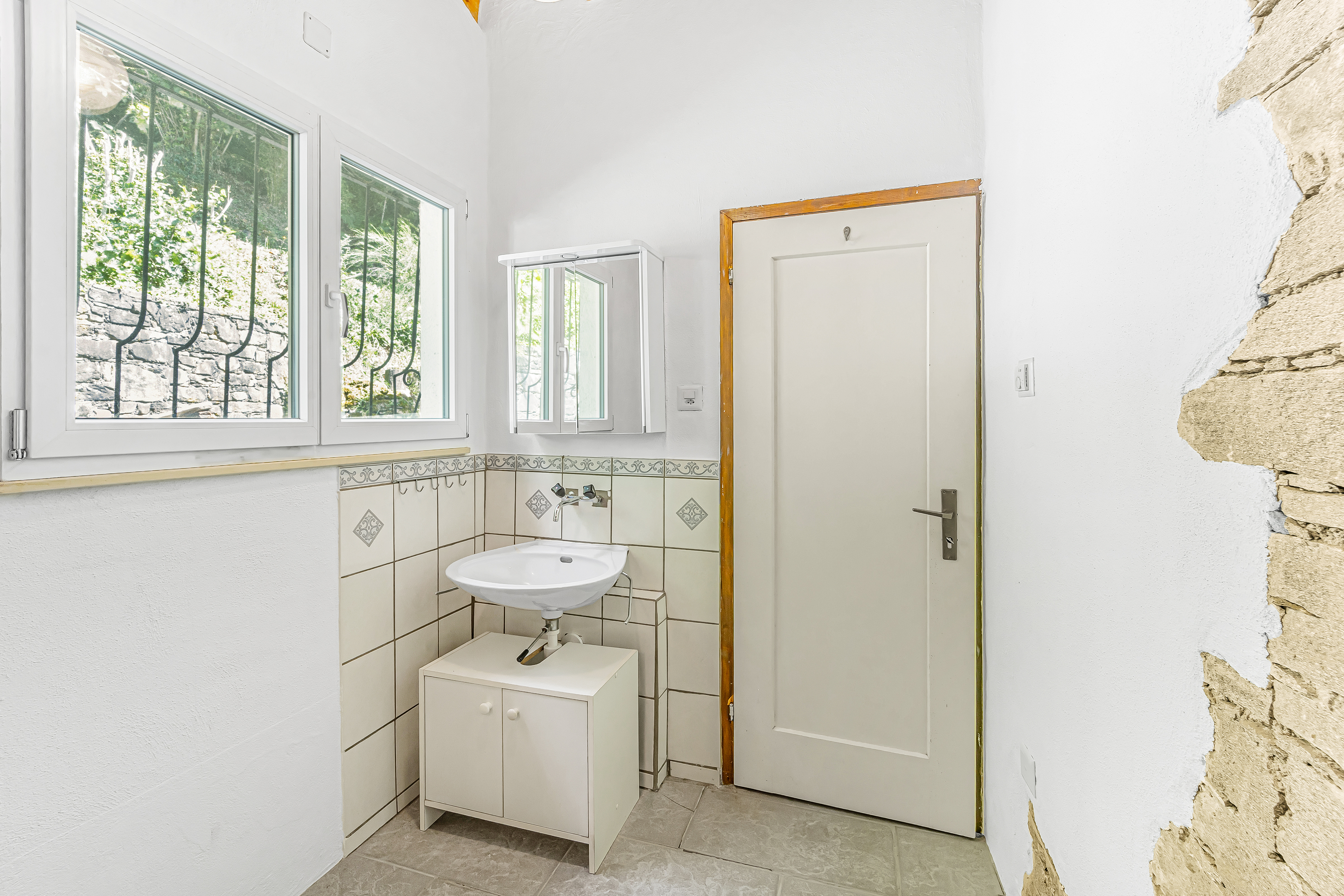Helles kleines Badezimmer mit Waschbecken und Fenster