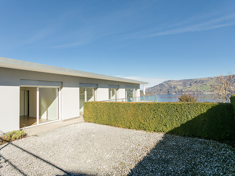 Seeblick von einer modernen Terrasse mit Garten