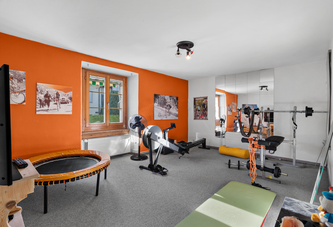 Heimischer Fitnessraum mit orangefarbener Akzentwand
