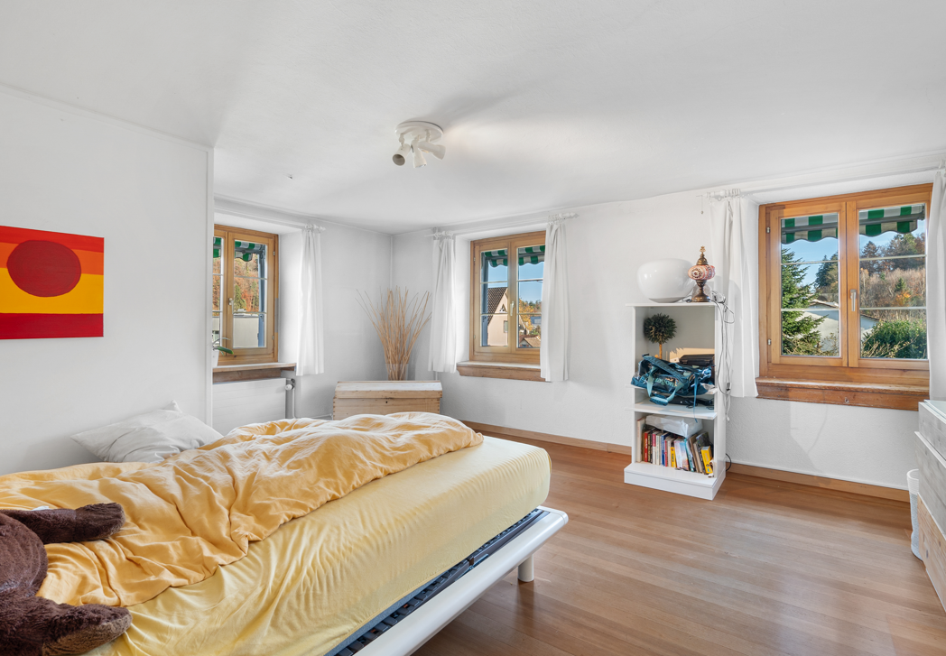 Helles Schlafzimmer mit Holzwindows und gelber Bettwäsche