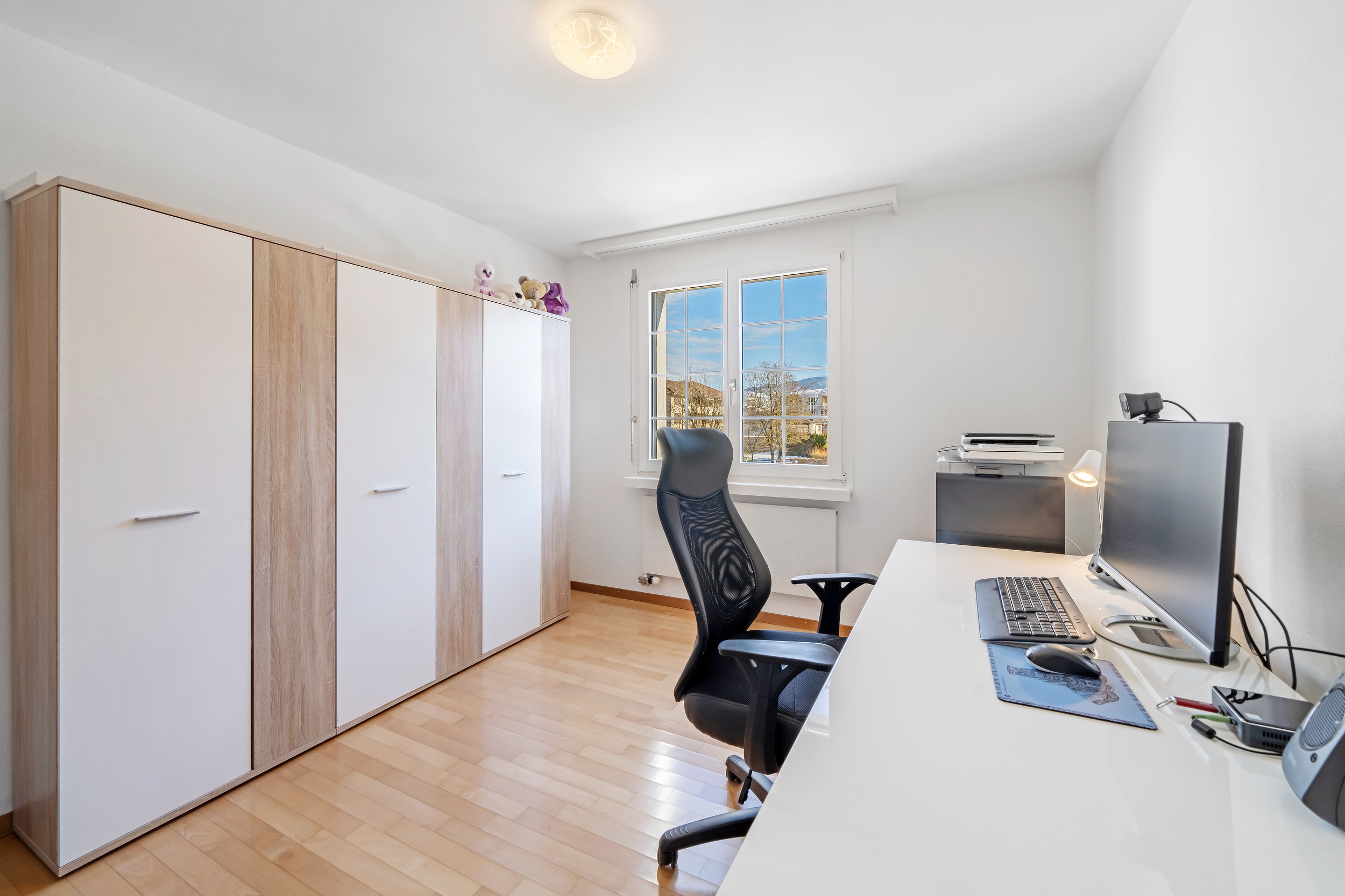 Helles Arbeitszimmer mit Einbauschrank und Schreibtisch