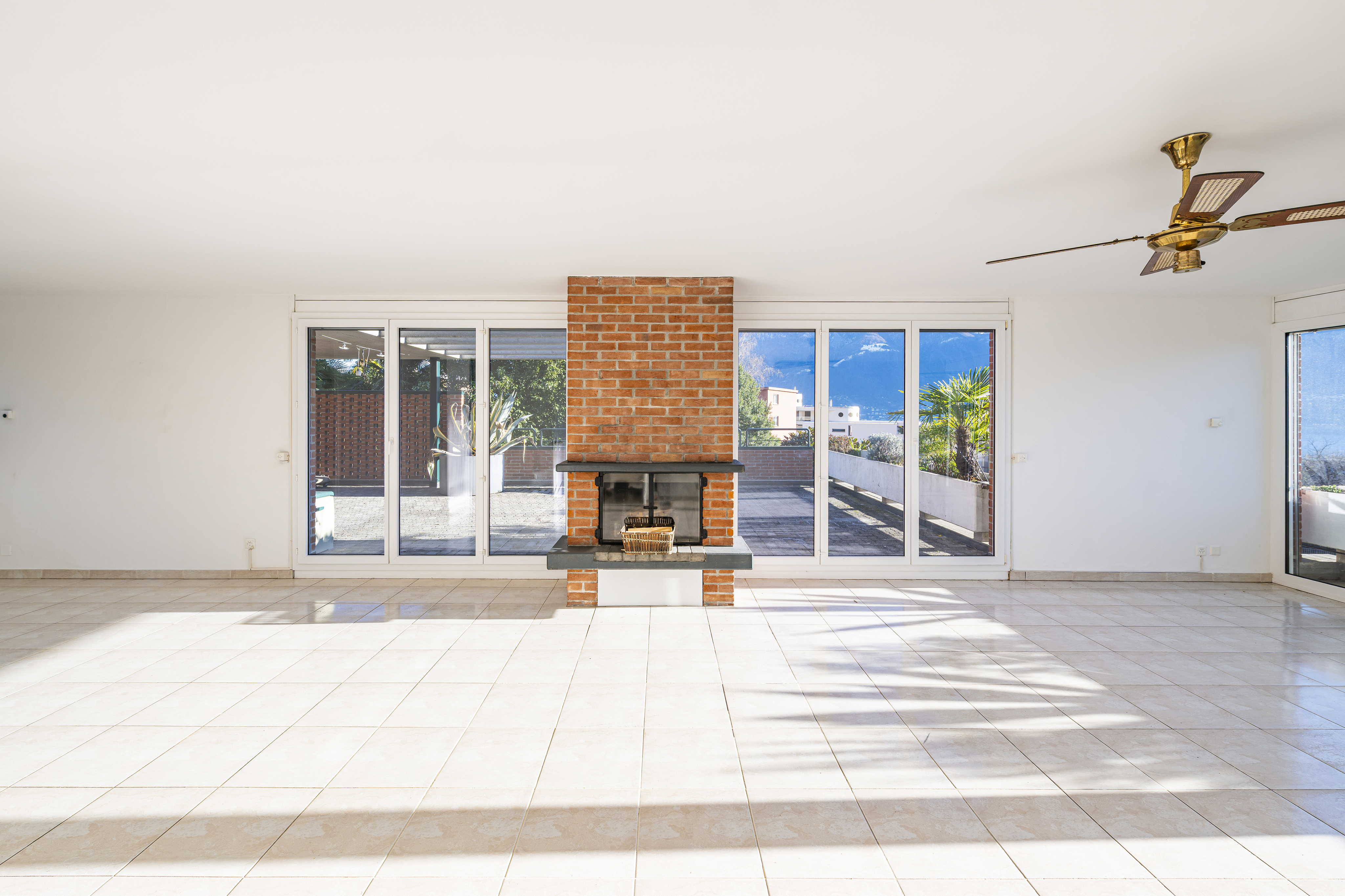 Heller Wohnraum mit großem Kamin und Panoramafenstern