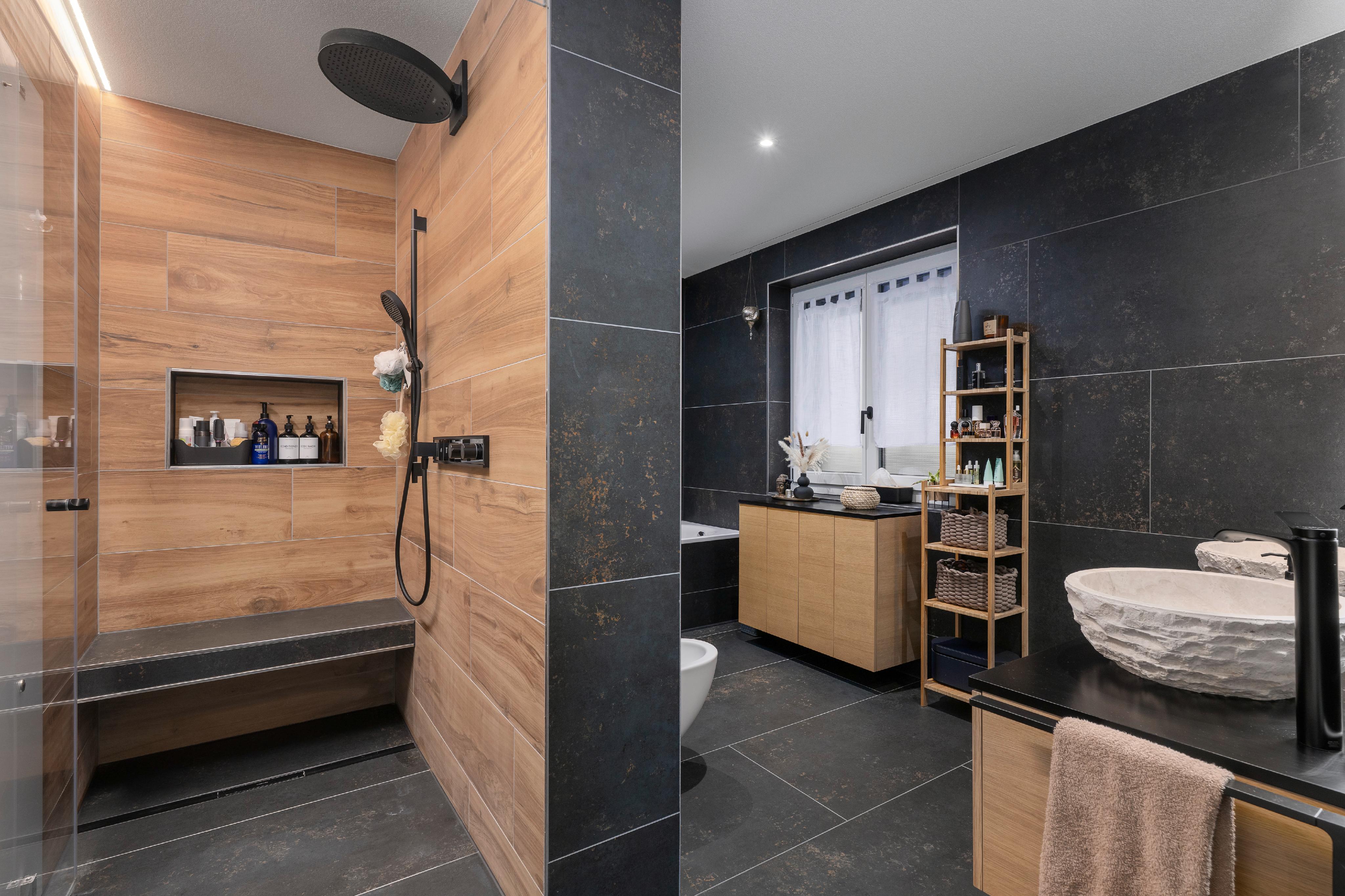 Modernes Badezimmer mit dunklen Fliesen und Holzakzenten