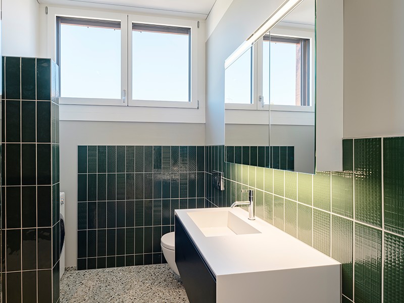 Modernes Gäste-WC mit grün gefliesten Wänden