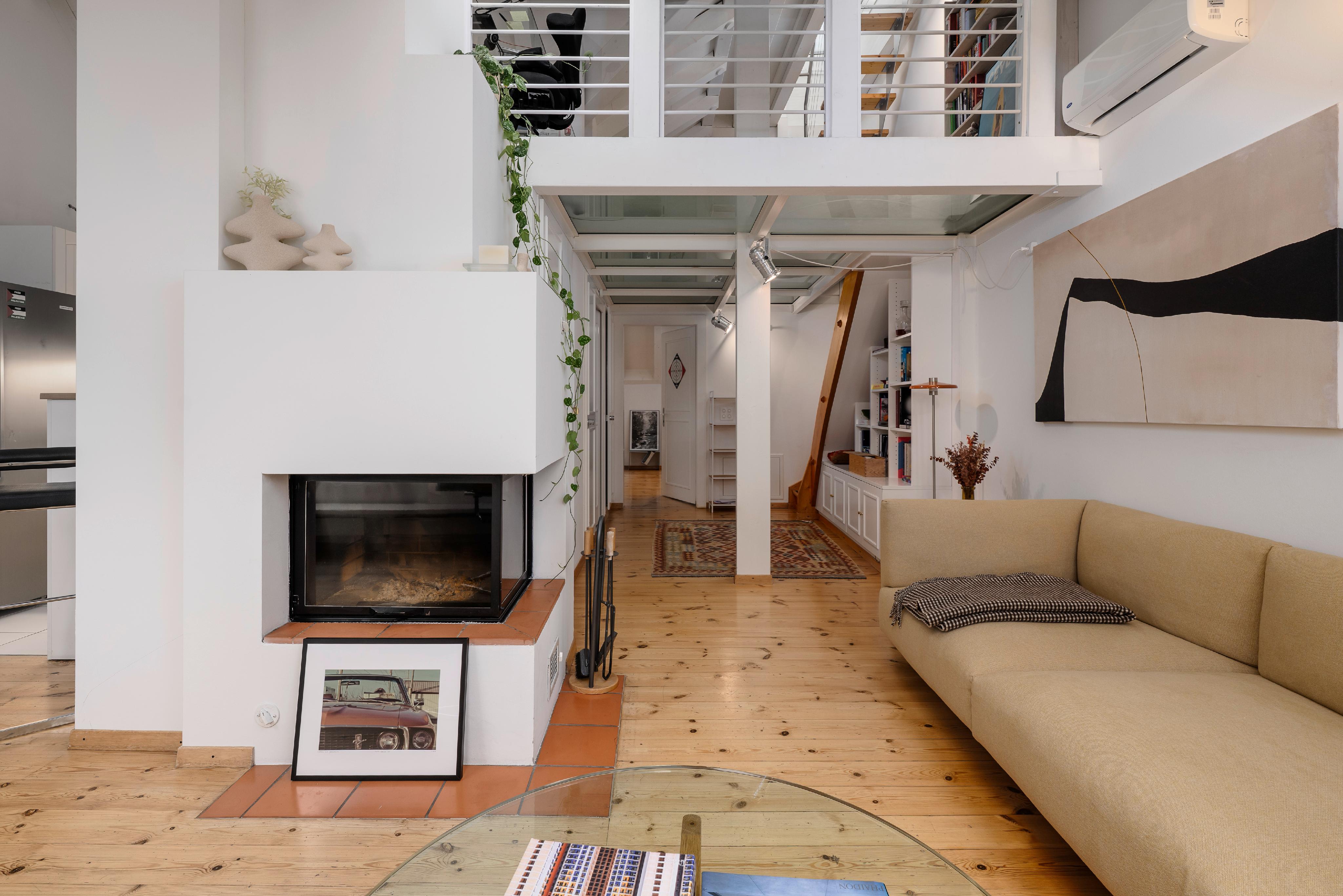Modernes Loft-Wohnzimmer mit Kamin und Galerie