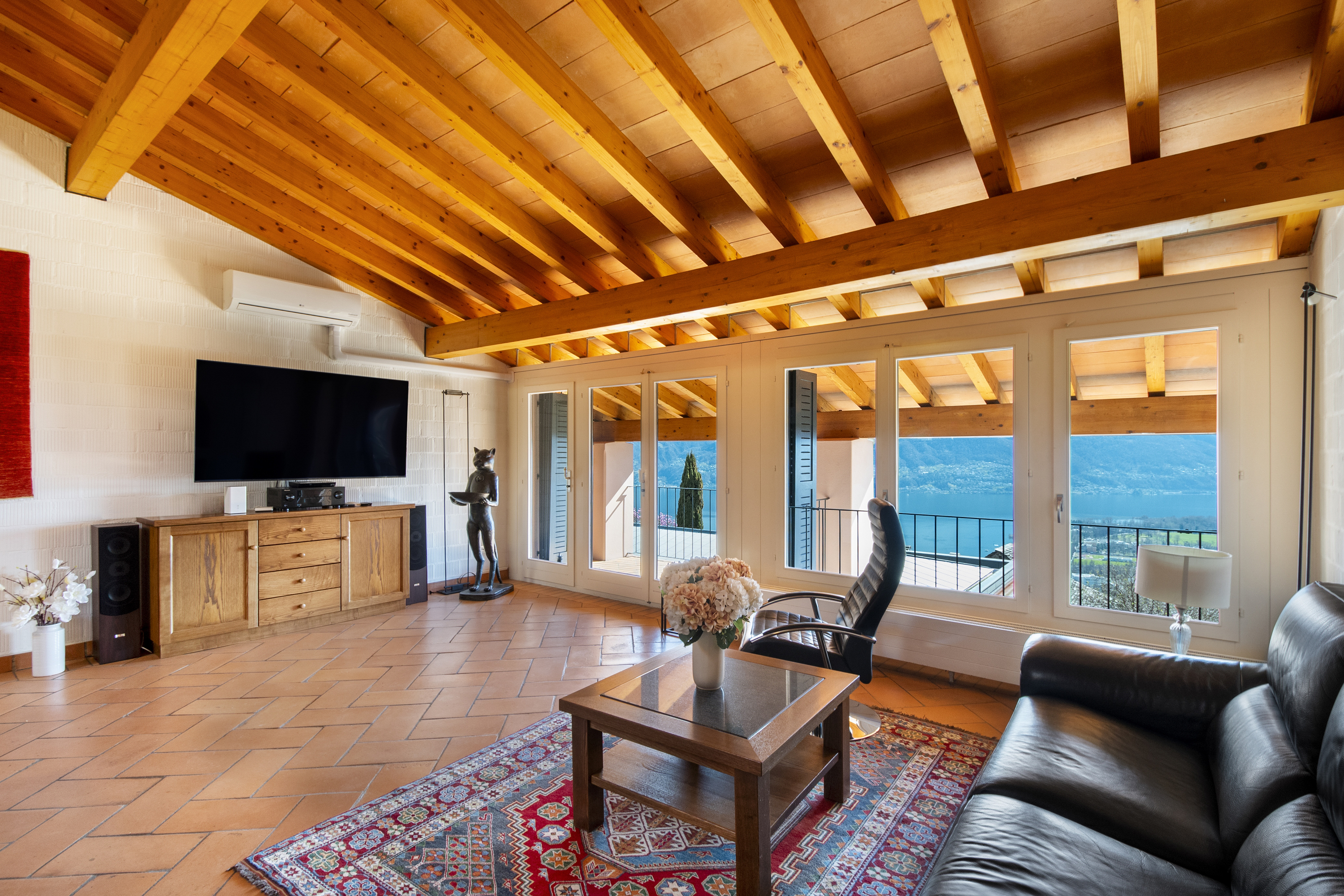 Wohnzimmer mit Holzdecke und Seeblick