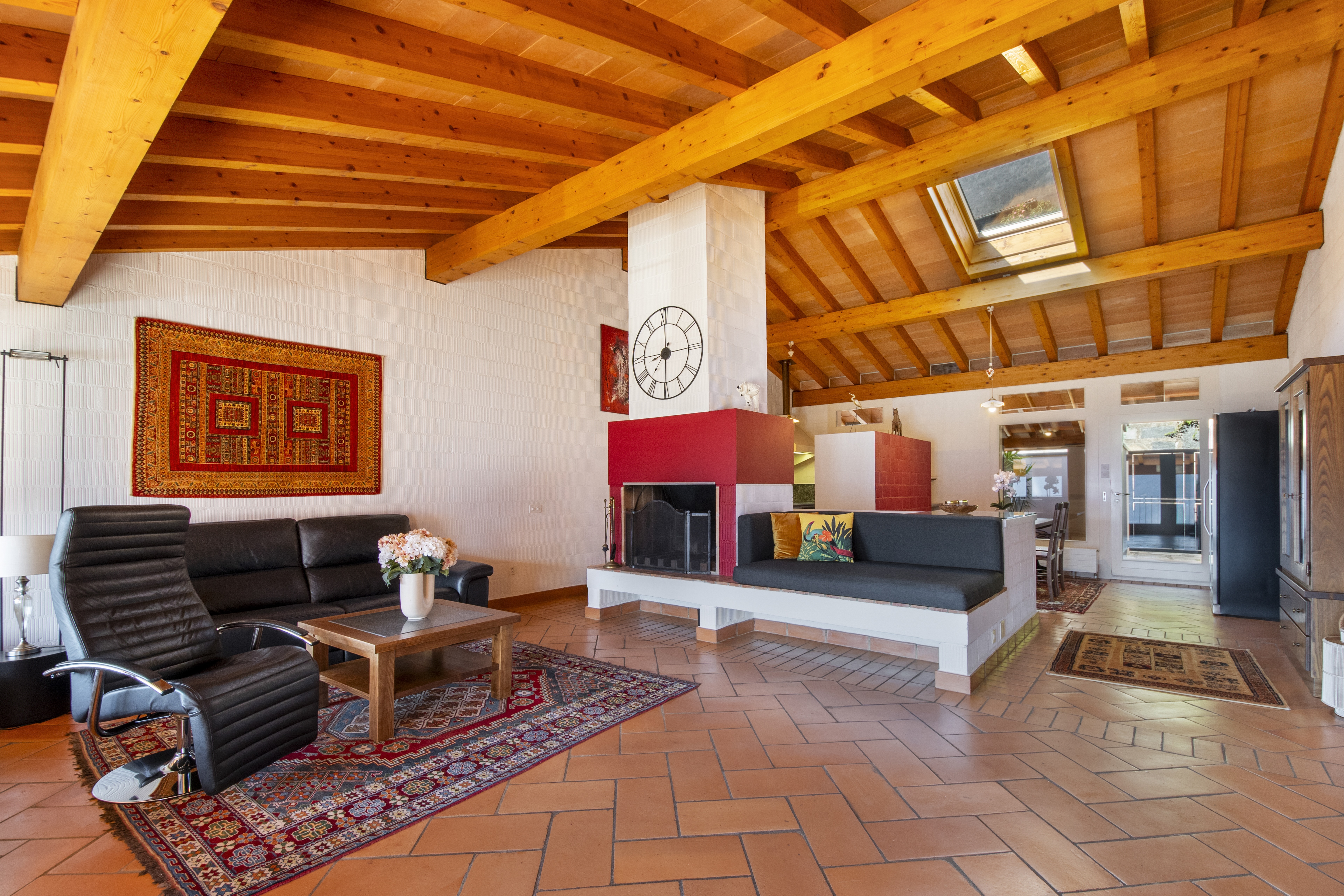 Wohnzimmer mit sichtbaren Holzbalken und Kamin