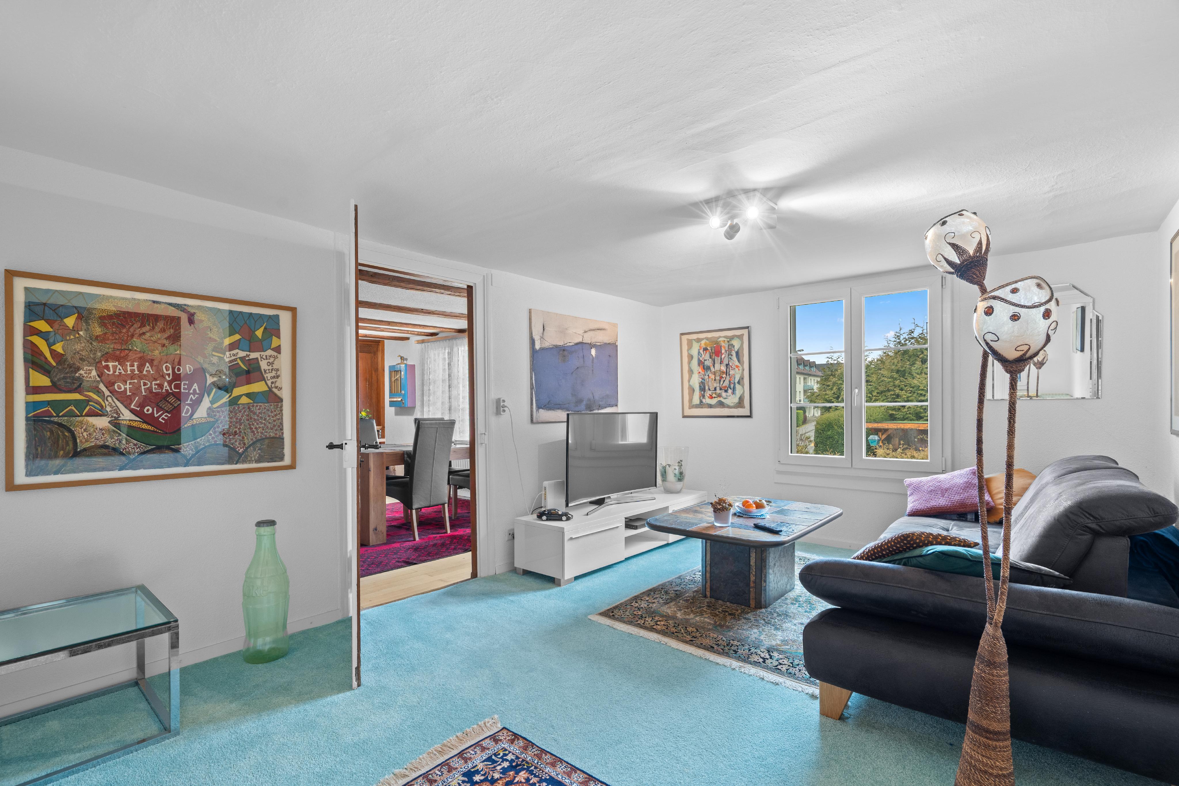 Helles Wohnzimmer mit Kunstwerken und Sofa