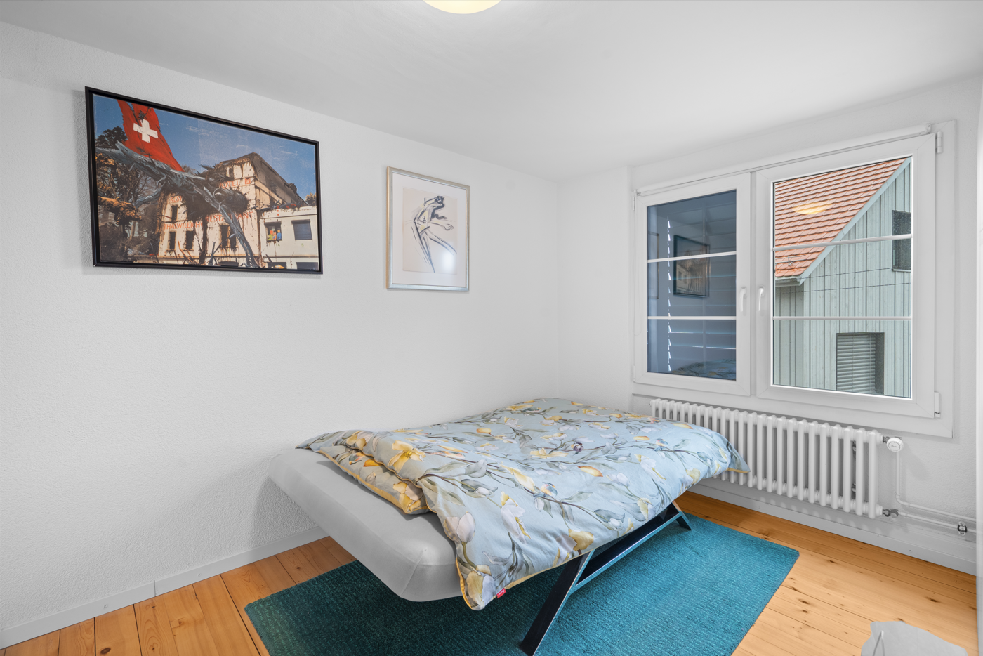 Helles Schlafzimmer mit Einzelbett und Fenstern